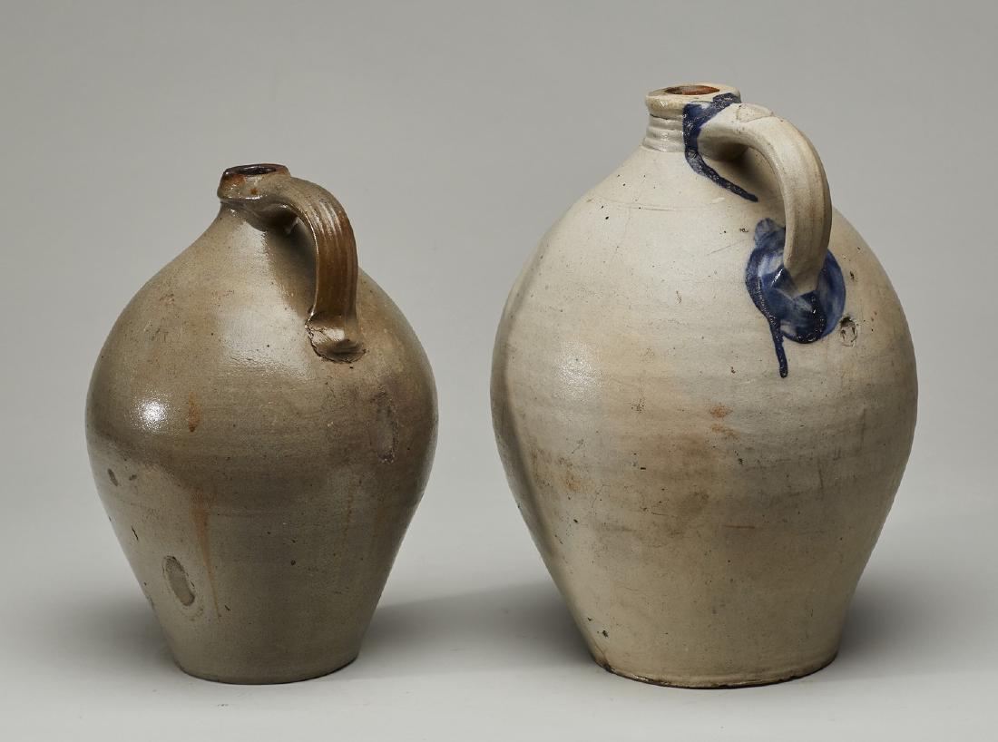 Two 19C Stoneware Ovoid 14 inch Stoneware Jugs: Two 19C Stoneware Ovoid Stoneware Jugs. The larger jug which measures 14 inches high, has a splash of blue on the handle, there is a old glaze pop near the bottom of the handle and some dots of white 