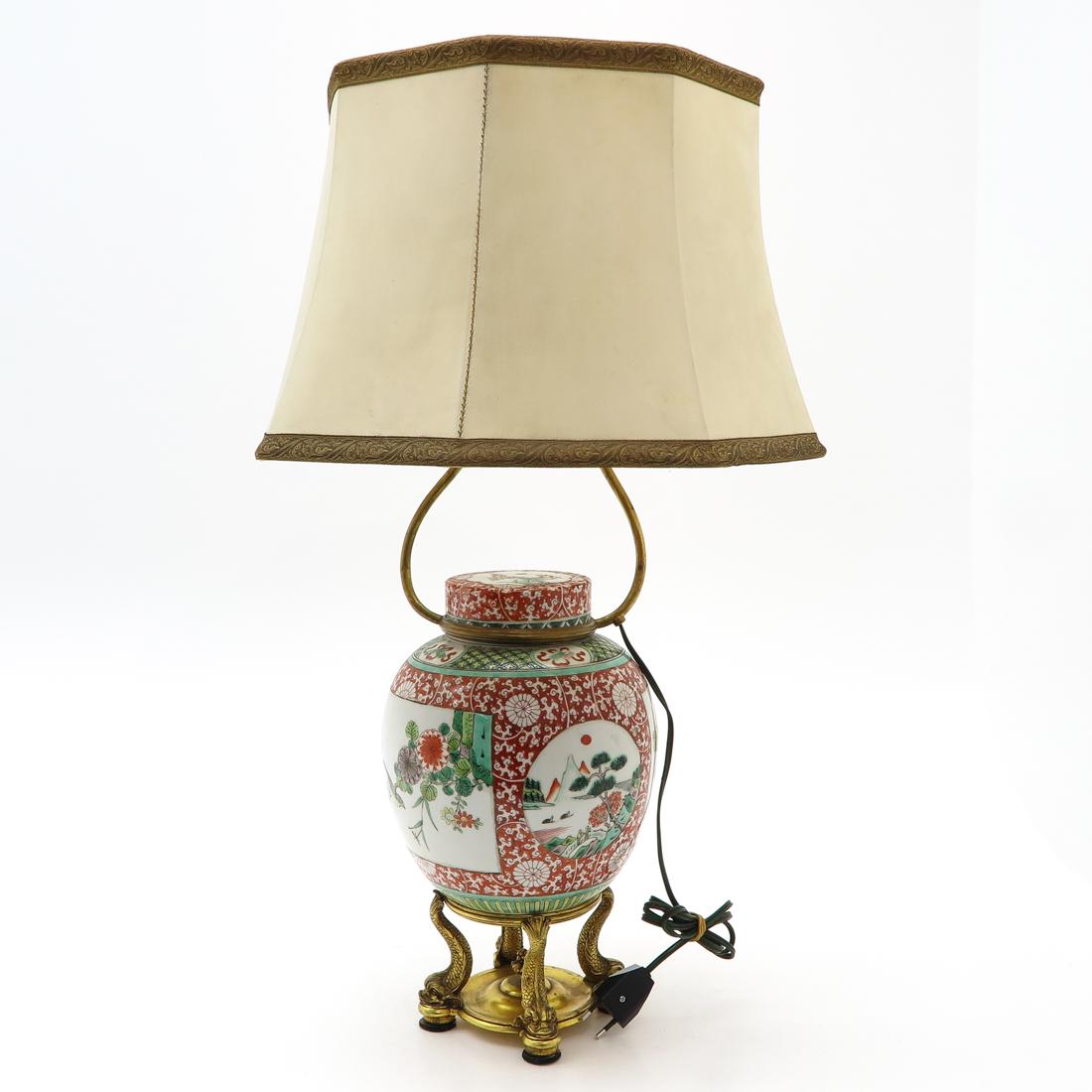 Lamp: Polychrome decor depicting alternating Chinese scenes, bronze dolphin decor on feet of lamp, 34 cm. tall.
