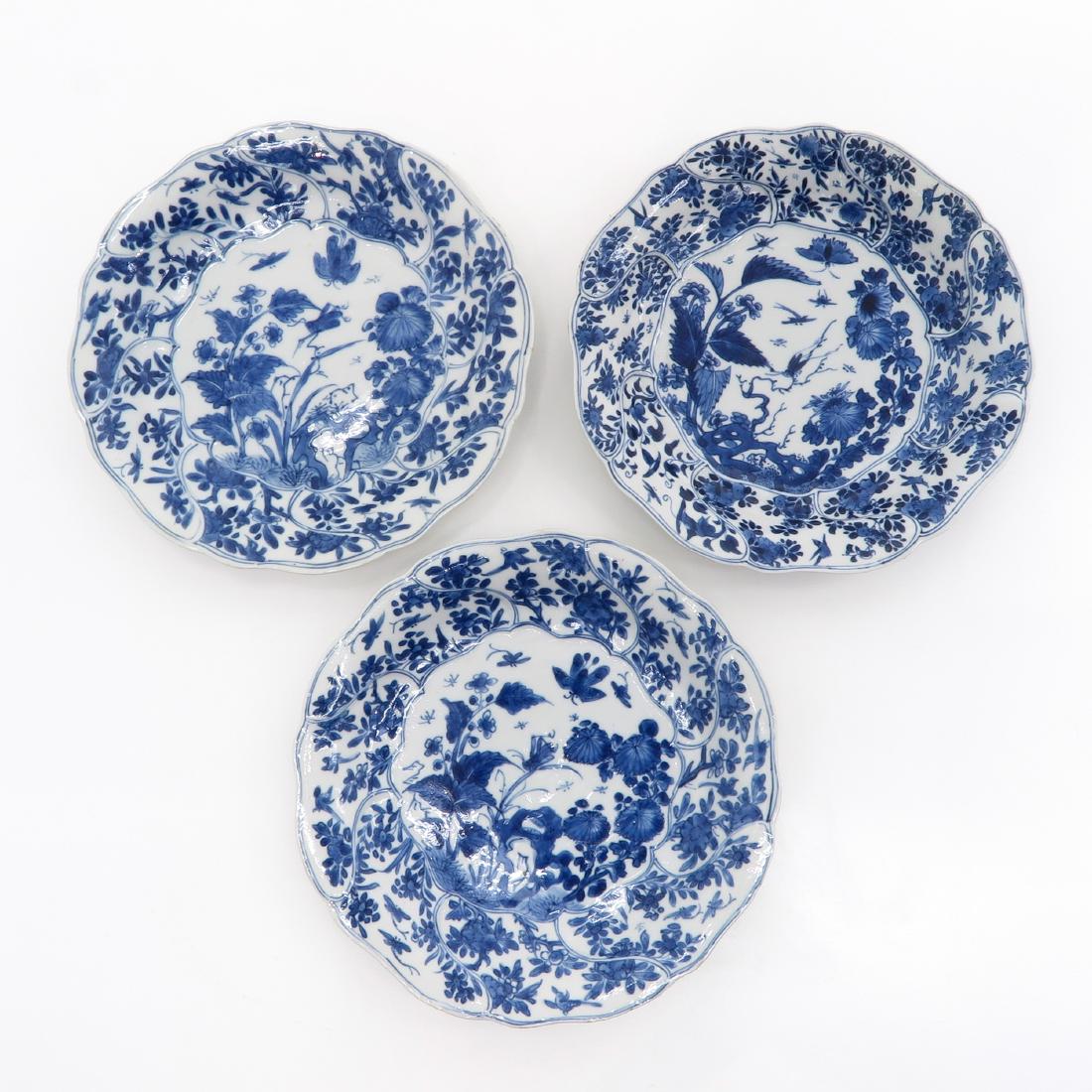 A Series of 3 Plates: Blue and white floral decor with crickets, scalloped edge, 18th Century, marked on bottom with double ring and flower, 22 cm. in diameter, in diverse conditions.