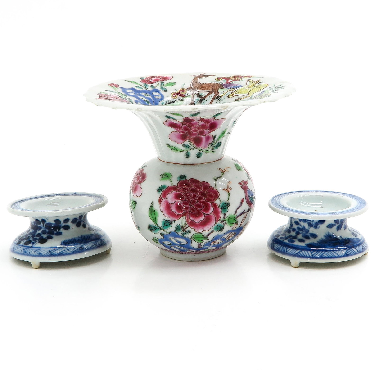 A Famille Rose Spittoon and Salt Cellars: Spittoon decorated with florals and animals 10 cm. tall, salt cellars in blue and white floral decor 6 cm. in diameter, spittoon is restored.