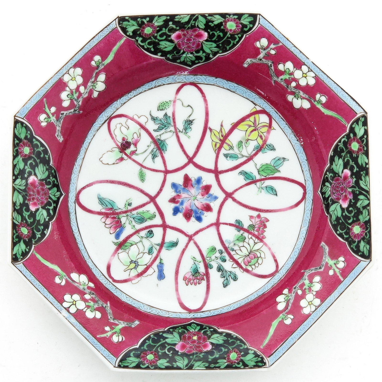 A Ruby and Famille Noir Decor Dish: Ruby ground with floral decors and blossom decors, 20 cm. in diameter.