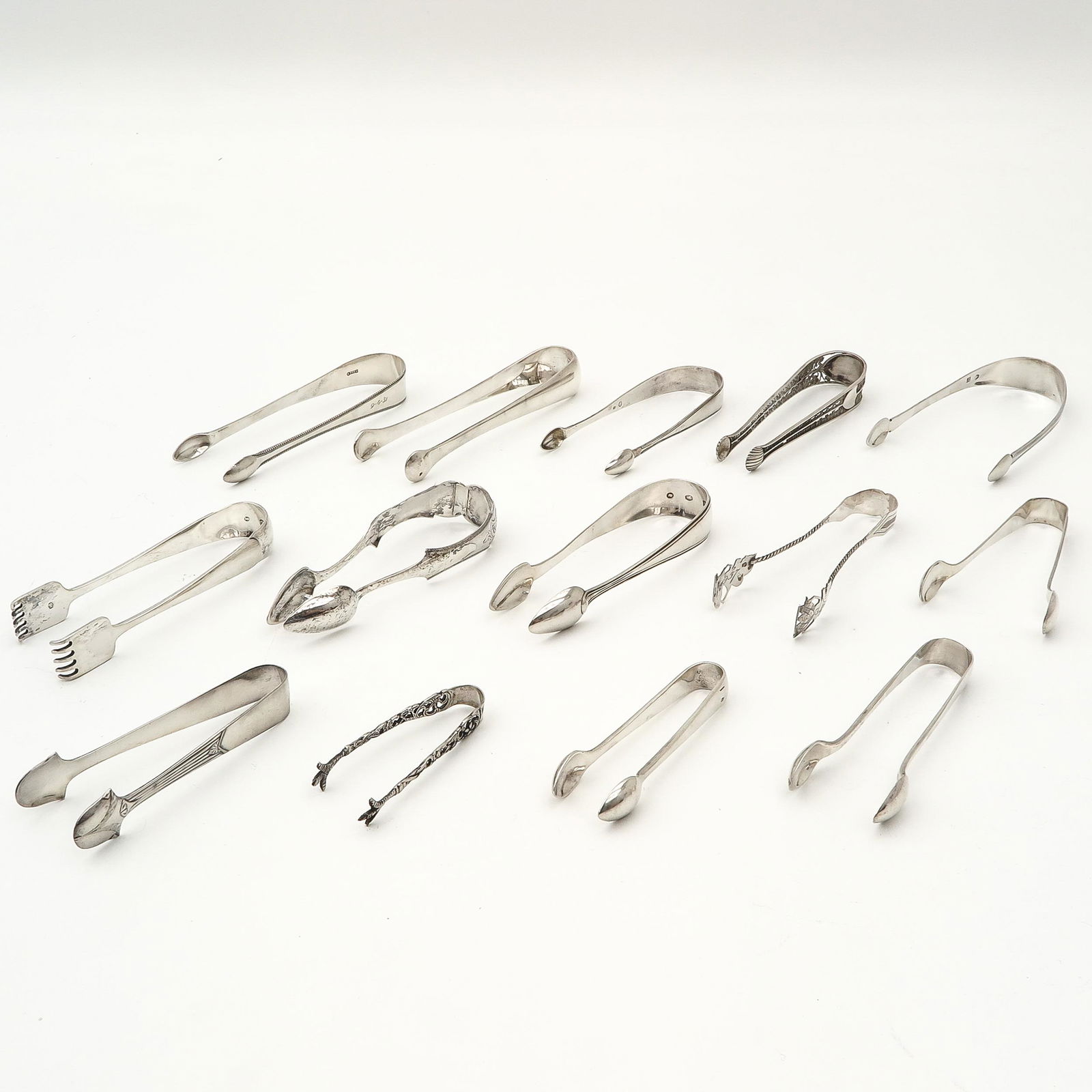 A Collection of Fourteen Sugar Tongs: Including Christofle France, English silver and Dutch silver, longest 15 cm.