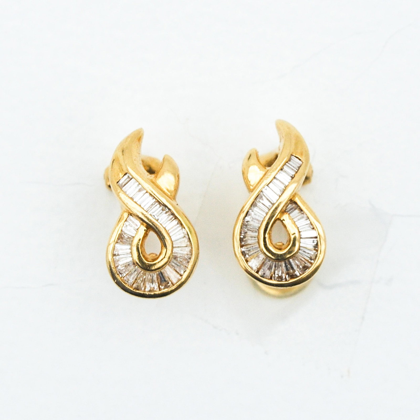 A Pair of 14KG Diamond Earrings: Set with baguette cut diamonds.