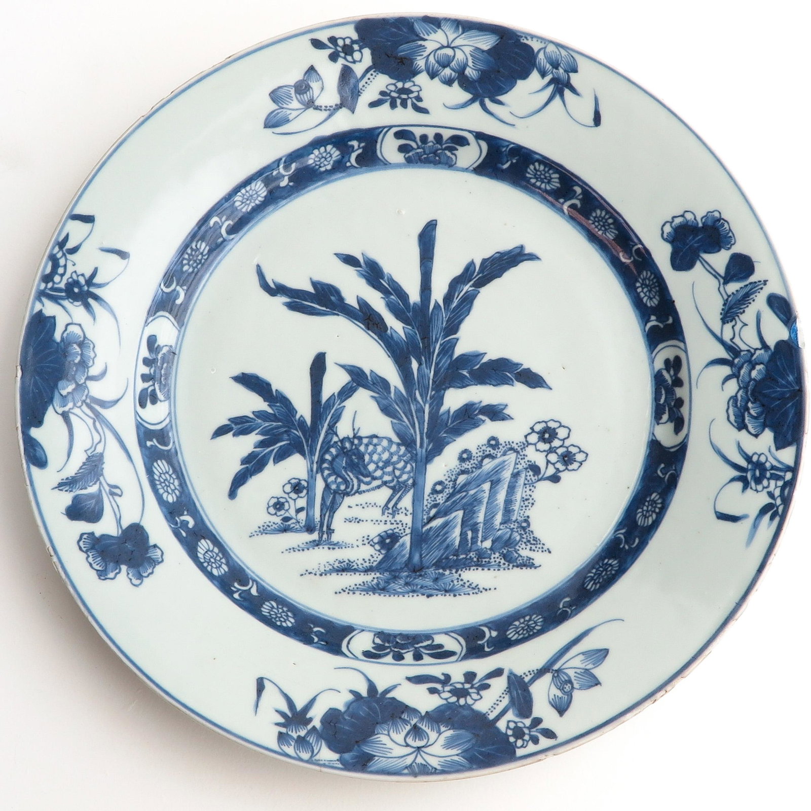 A Blue and White Charger: Depicting deer in garden, floral border decor, 31 cm. in diameter, chip.