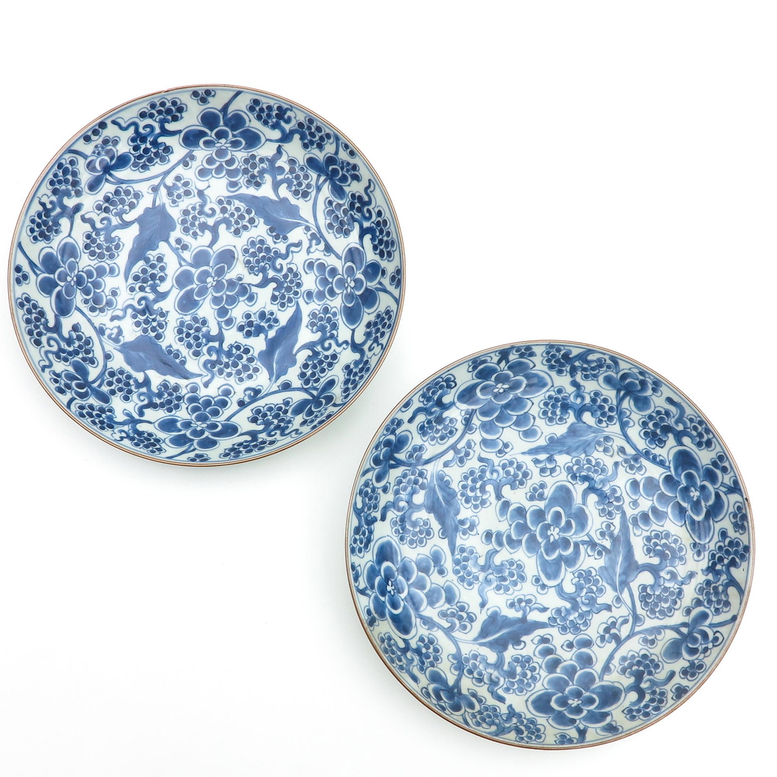 A Pair of Blue and White Plates: Decorated with flowers and grapevines, 28 cm. in diameter, hairline.