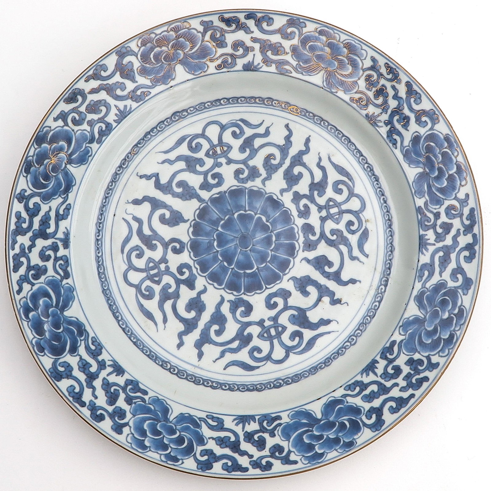 A Blue and White Charger: Floral decor with remnants of gilt accents, 35 cm. in diameter, chip.