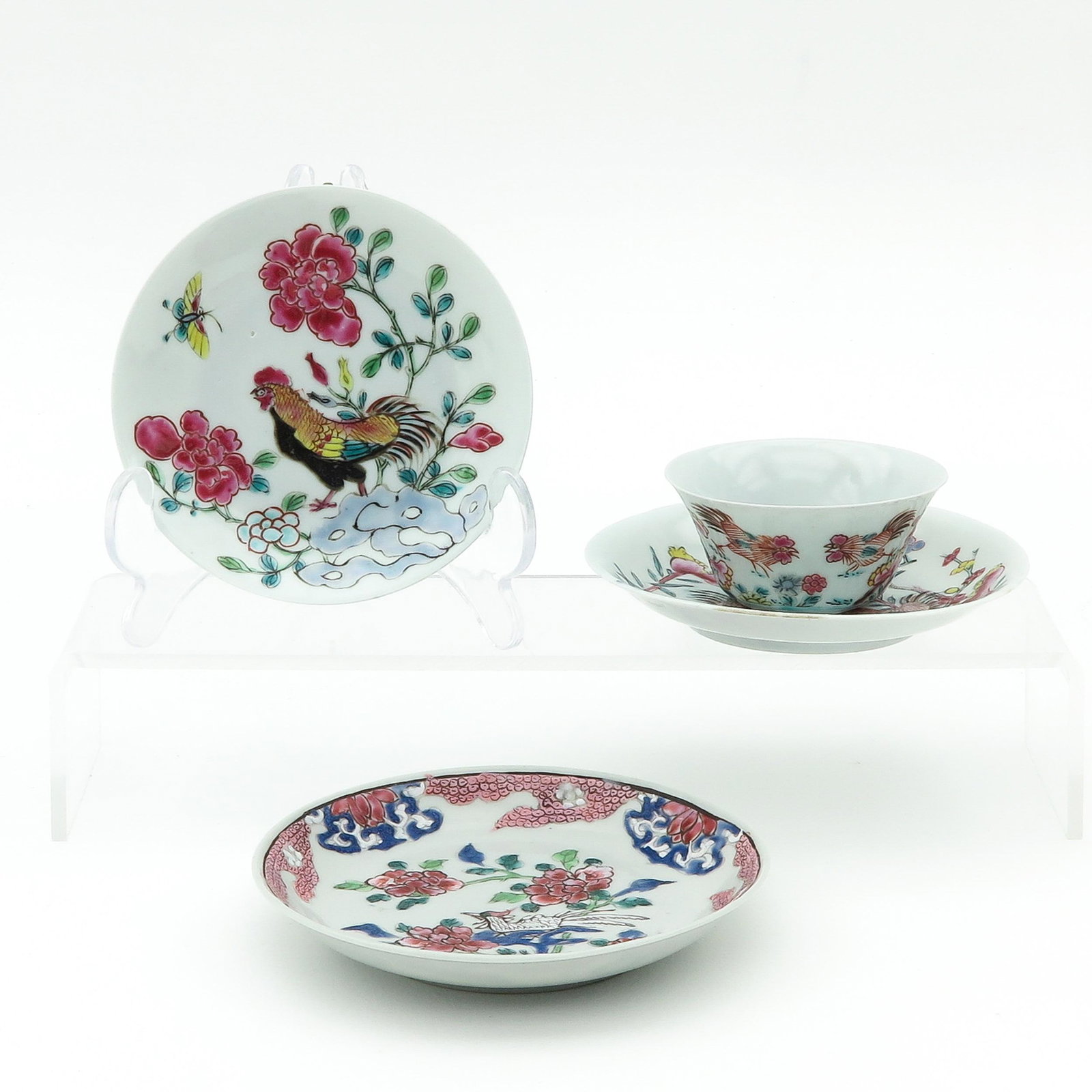 A Famille Rose Cup and 3 Saucers: Decorated with flowers and roosters, largest saucer is 12 cm. in diameter, chip and hairline