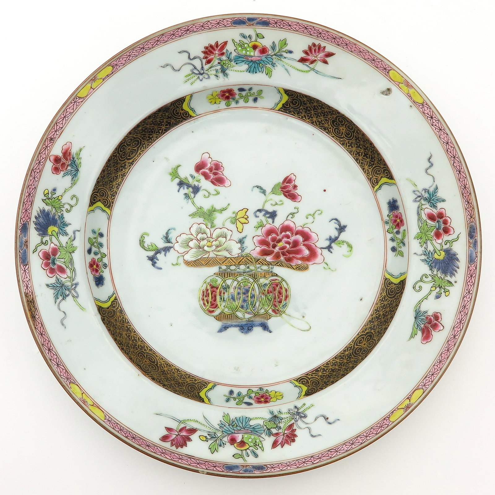 A Famille Rose Plate: Decorated with flowers in vase with floral border, 29 cm. in diameter, chip.
