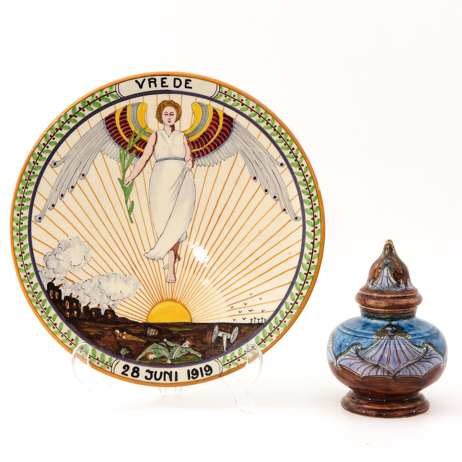 A Gouda Saucer and Rozenburg Pot: consisting of a Gouda 1919 saucer and a pot with lid from Rozenburg The Hague, height 16 cm.