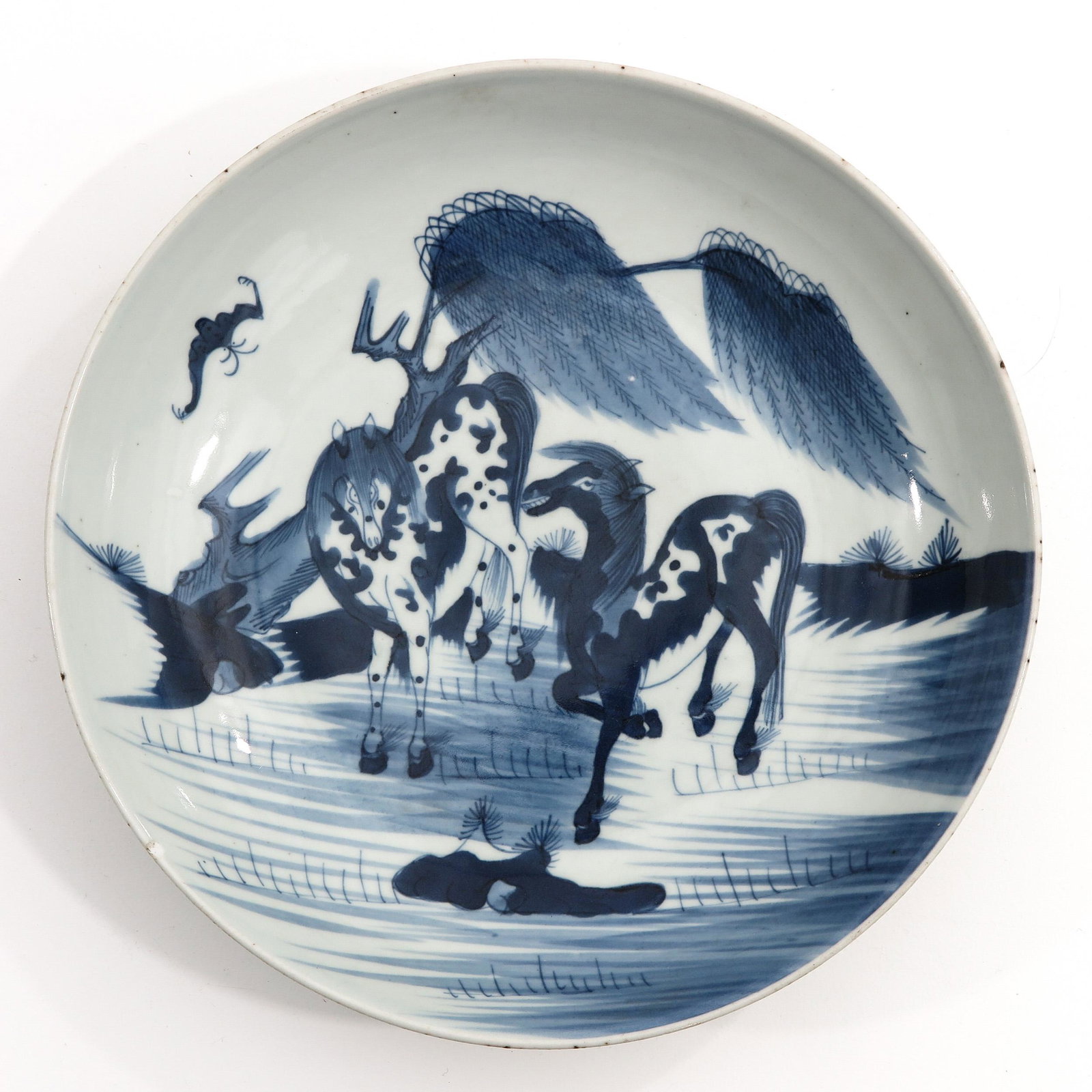A Blue and White Dish: Depicting scene with horses, 29 cm. in diameter, chip.
