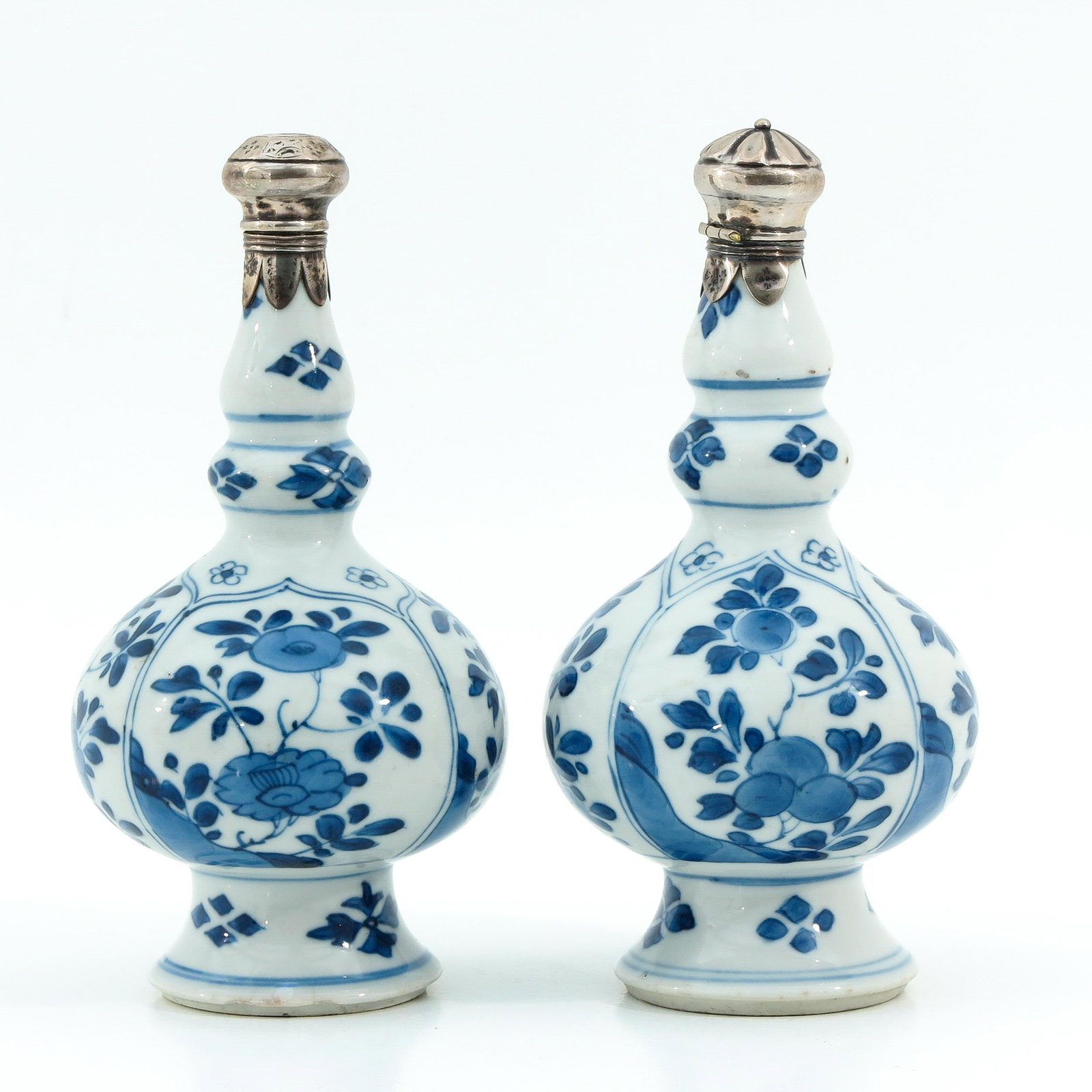 A Pair of Rose Water Sprinklers: Floral decor, Kangxi Period, 16 cm. tall with silver tops, chip.