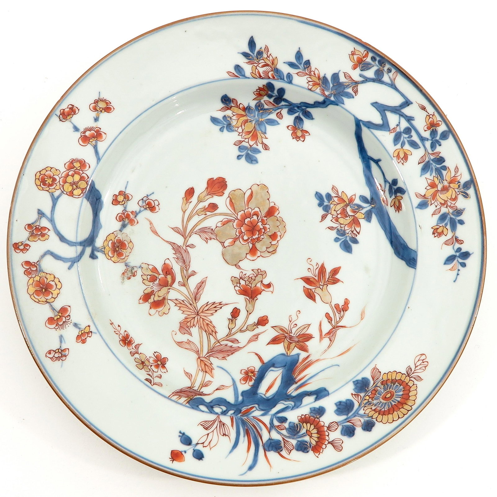 An Imari Plate: Iron red, blue and gilt floral decor, 18th Century, 27 cm. in diameter, chip.