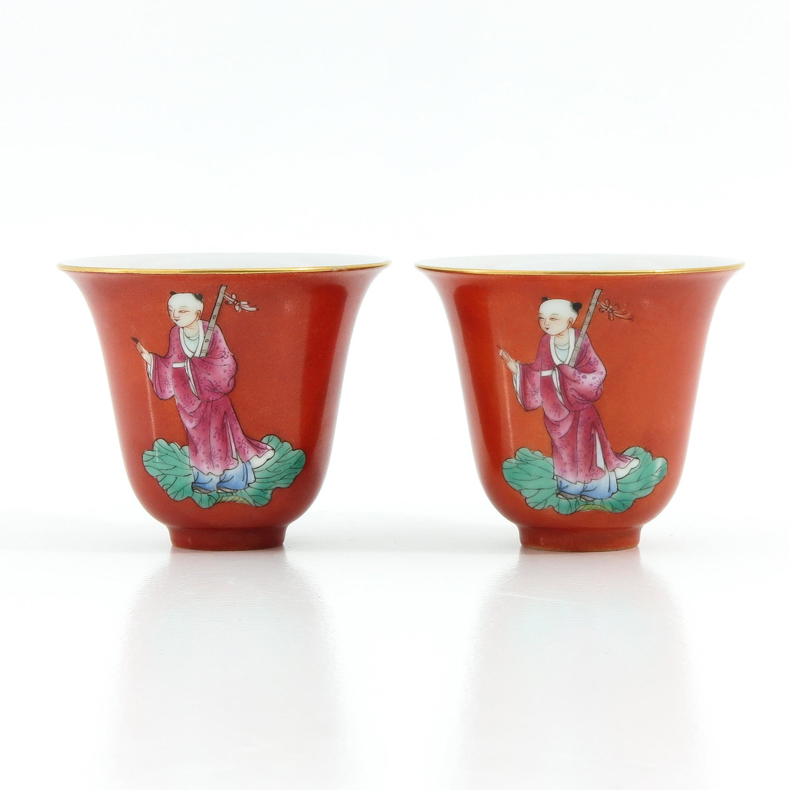 A Pair of Famille Rose Cups: Orange ground decorated with Chinese figures in Famille Rose enamels, 7 cm. in diameter.