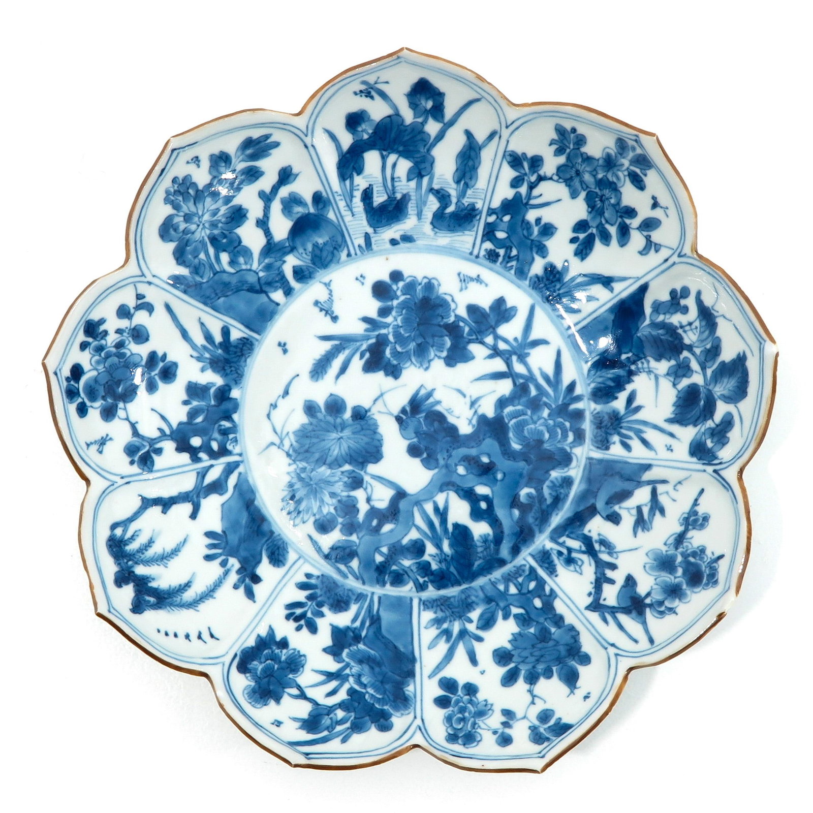 A Blue and White Plate: In the shape of a lotus flower, Kangxi Period, 23 cm. in diameter, 23 cm. in diameter, chip and hairline.