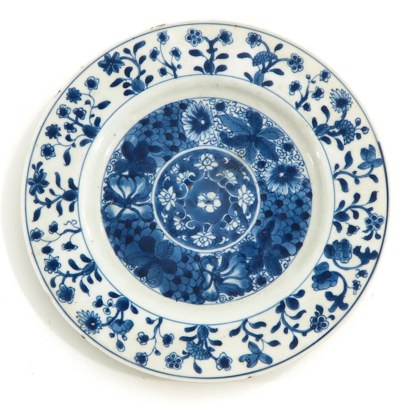 A Blue and White Plate: Floral decor, marked with double ring and lozenge, 25 cm. in diameter, chip and hairline.