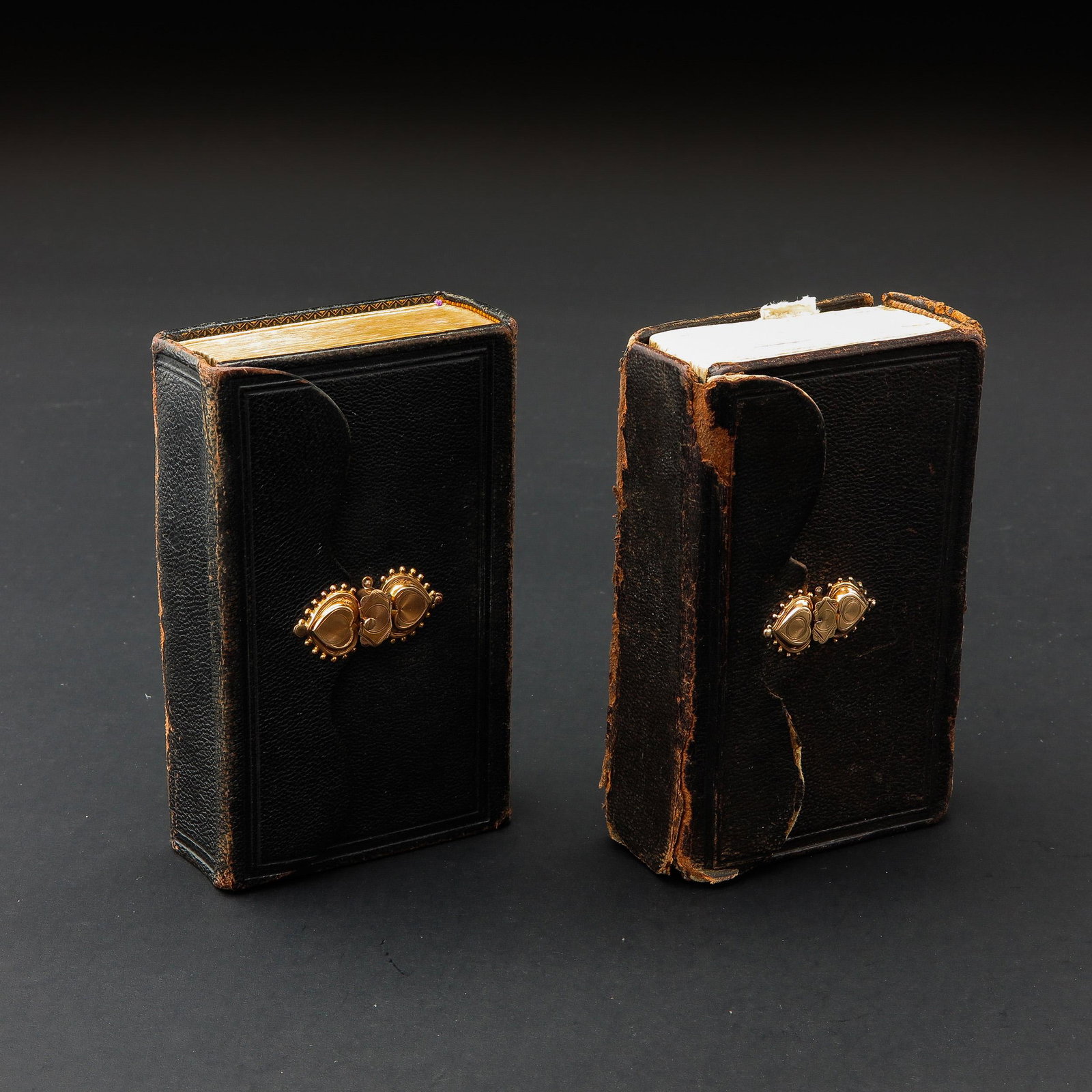 A Collection of 2 Bibles with Gold Clasps: 13 cm. tall.