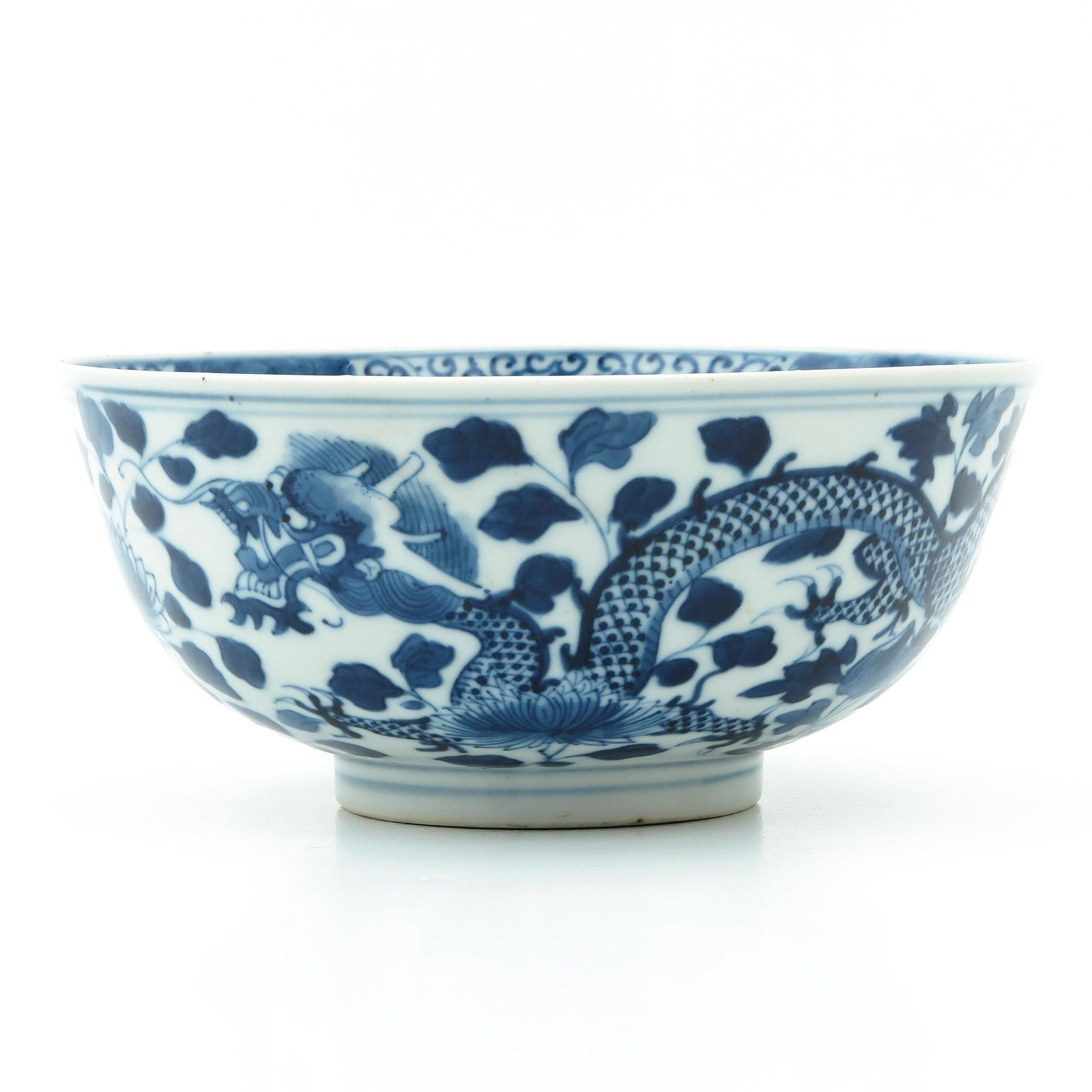 A Blue and White Bowl: Decorated with dragons and flowers, Kangxi mark, 18th - 19th Century, 19 cm. in diameter.