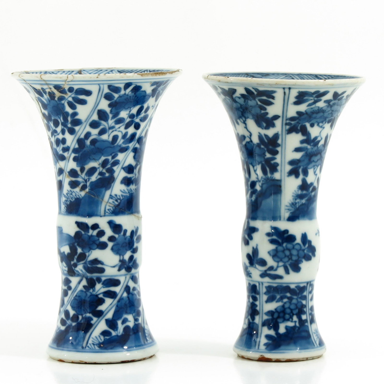 A Pair of Blue and White Garniture Vases: Floral decor, Kangxi Mark and Period, 13 cm. tall, one vase restored.