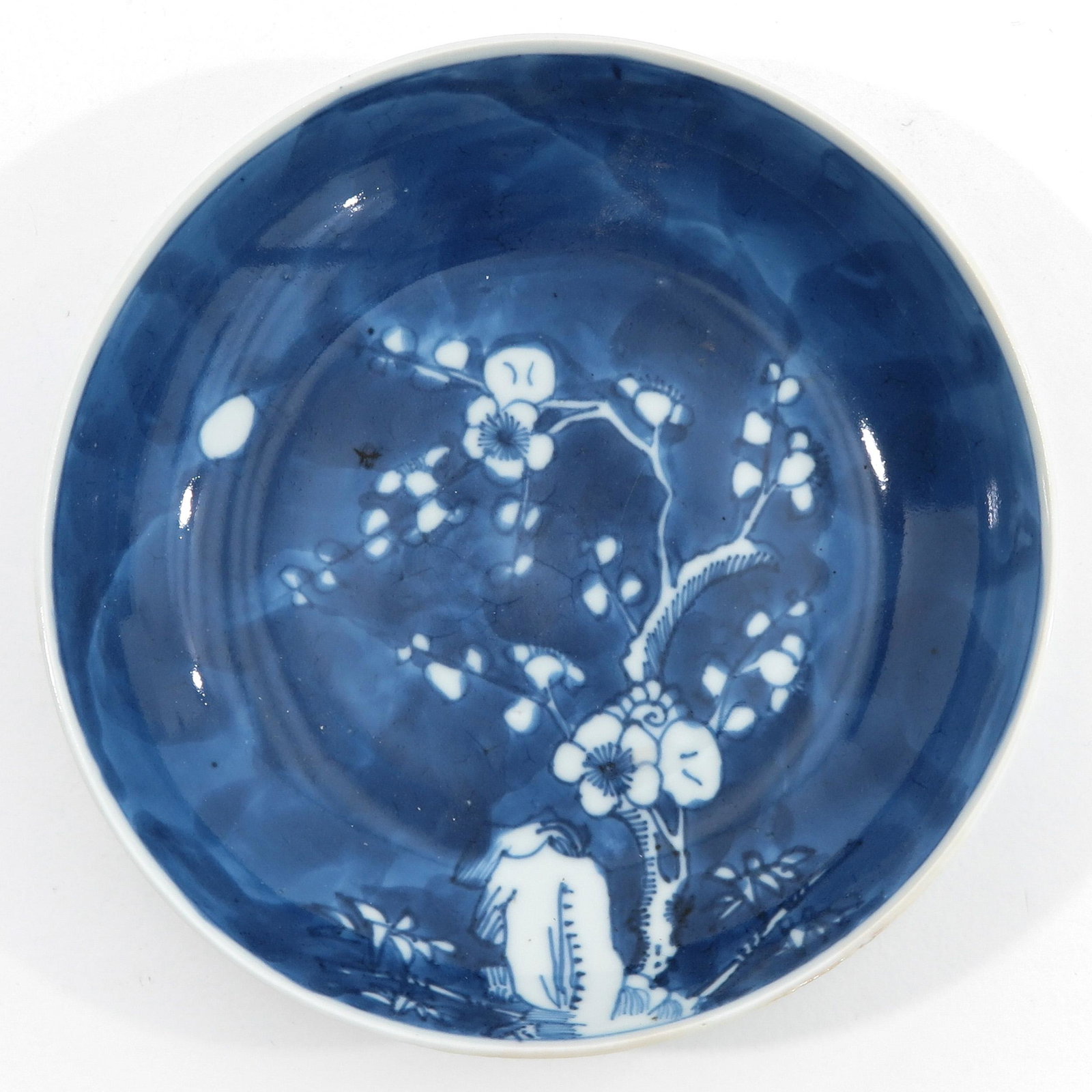 A Blue and White Plate: Blue ground with white blossom, Yongzheng mark, 16 cm. in diameter.