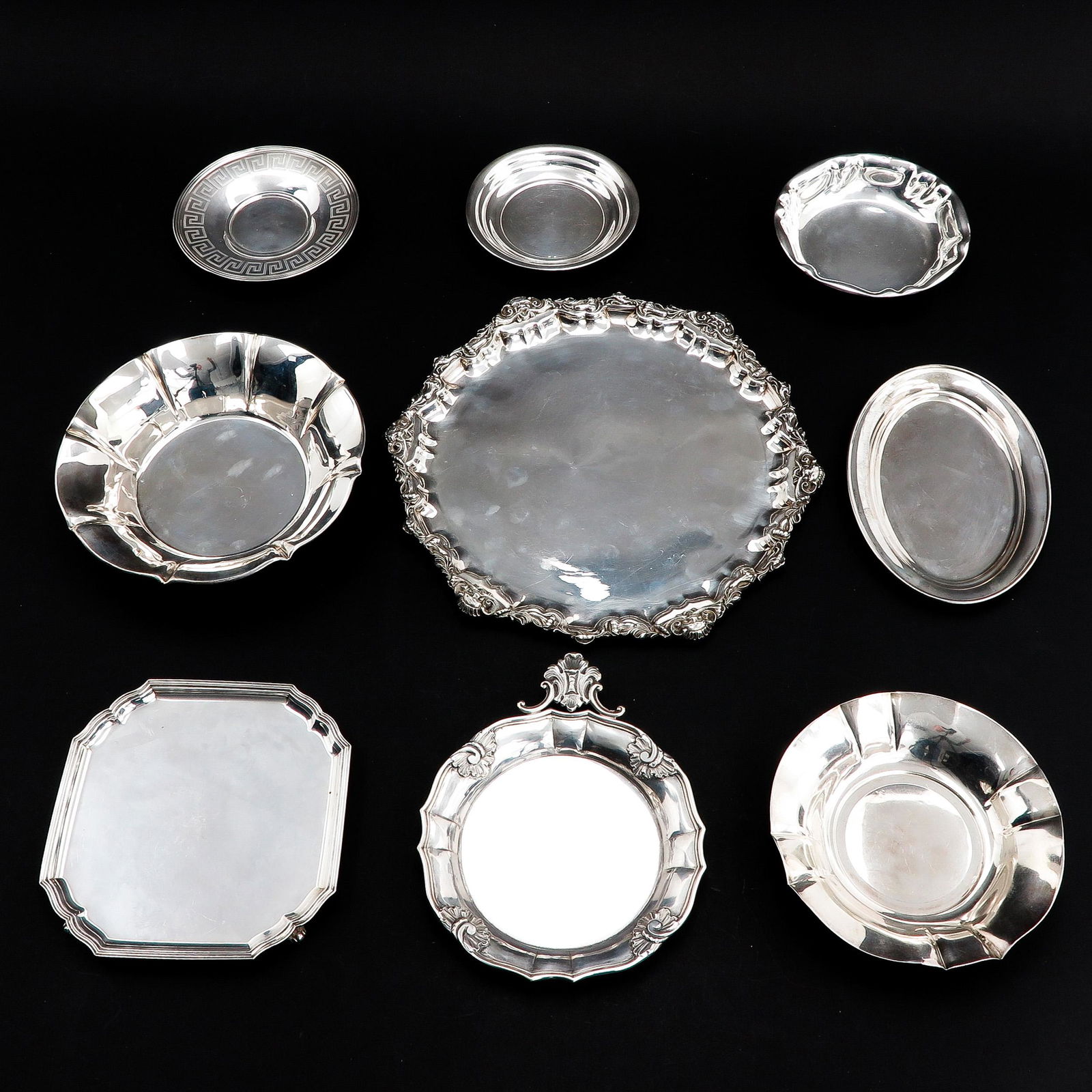A Lot of 9 Silver Trays: Longest 32 cm. in diameter.