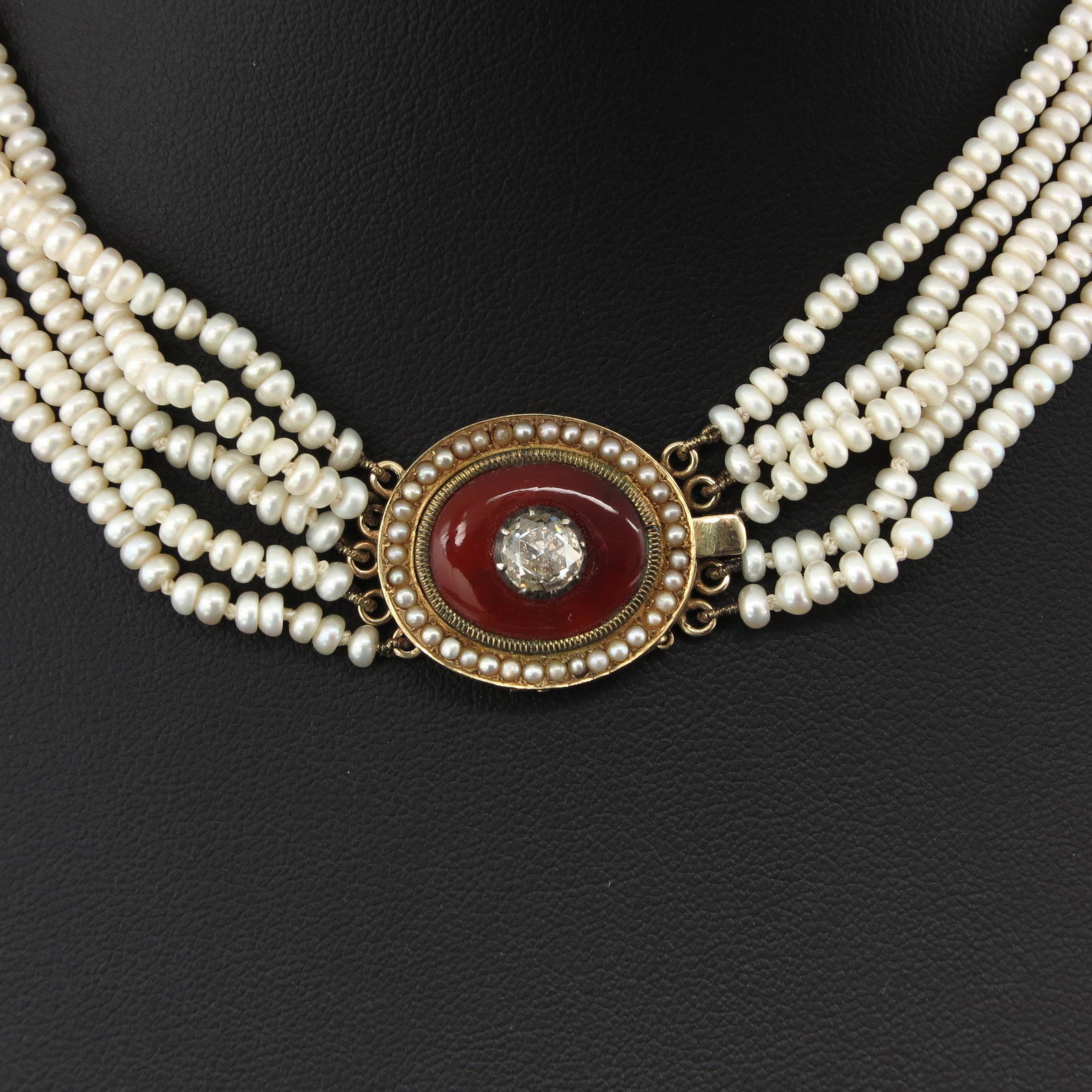 A Five Strand Pearl Necklace: On clasp set with rose cut diamond approximately 6 mm. in diameter.