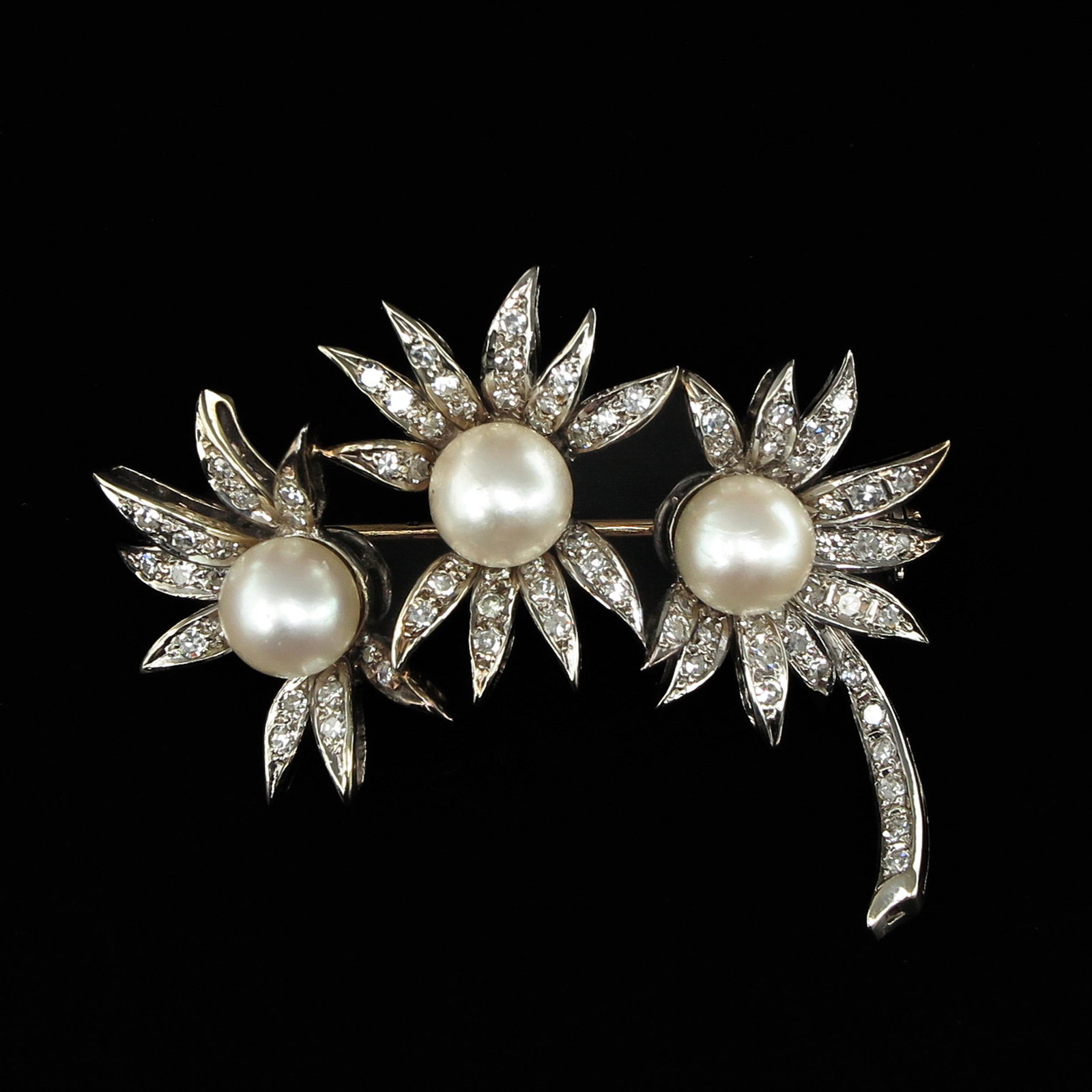 An 18KG Diamond and Pearl Brooch: Set with brilliant cut diamonds and 3 pearls, 8 mm. in diameter, 47 mm. long.