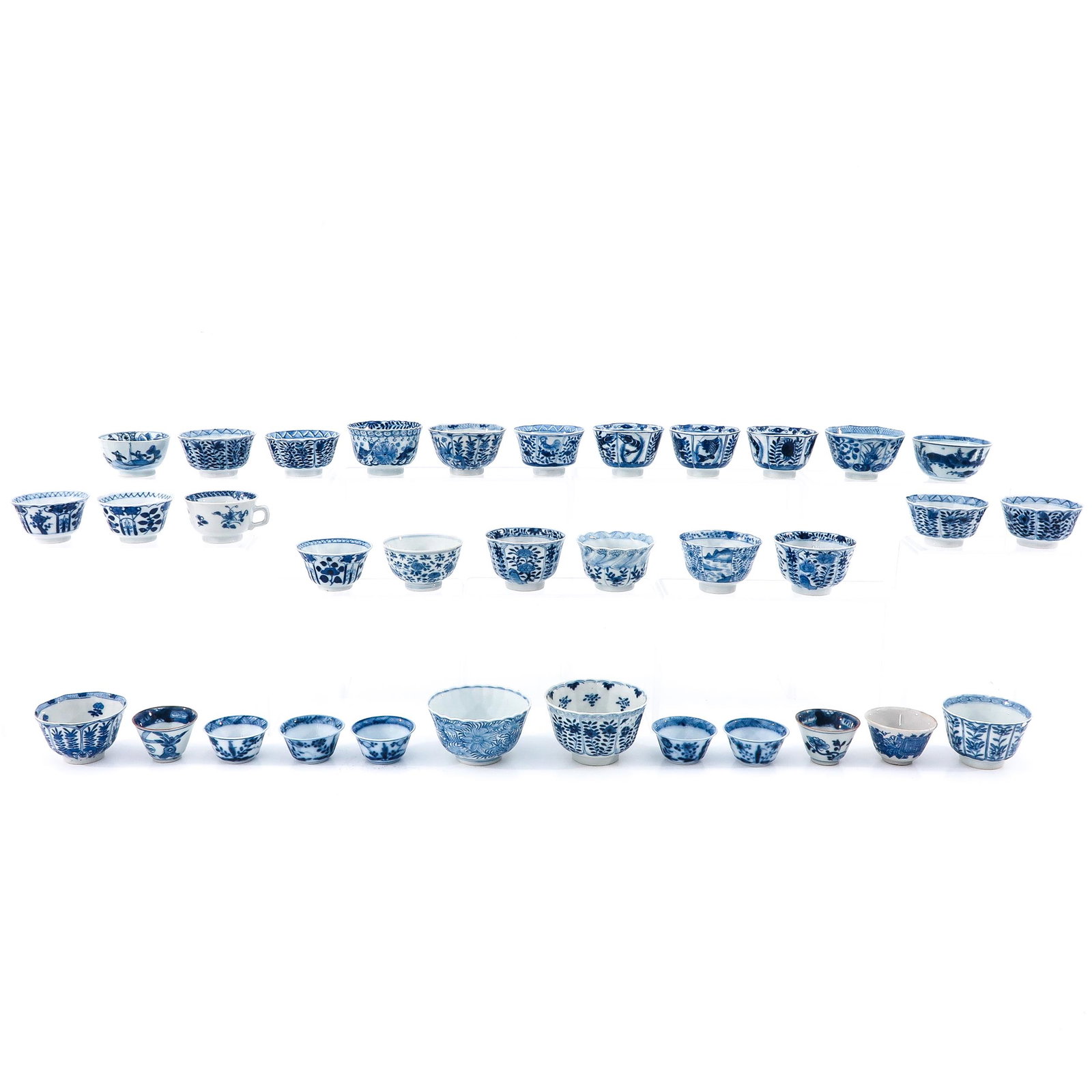 A Collection of 34 Cups: In a variety of blue and white decors and sizes, including 18th Century, largest cup is 10 cm. in diameter, with restoration.
