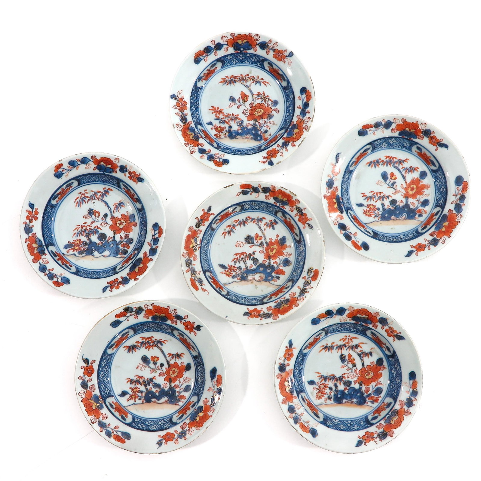 A Series of 6 Imari Plates: Iron red, blue and gilt floral decor, 18th Century, 17 cm. in diameter, chip.