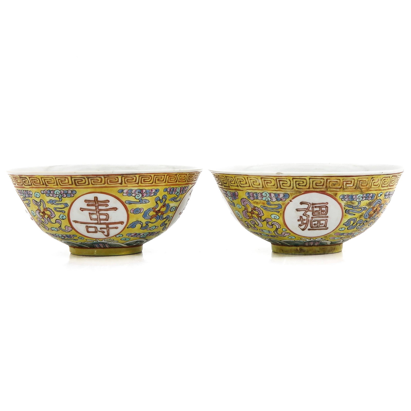 A Pair of Famille Rose Bowls: Yellow ground decorated with Chinese symbols, 17 cm. in diameter.