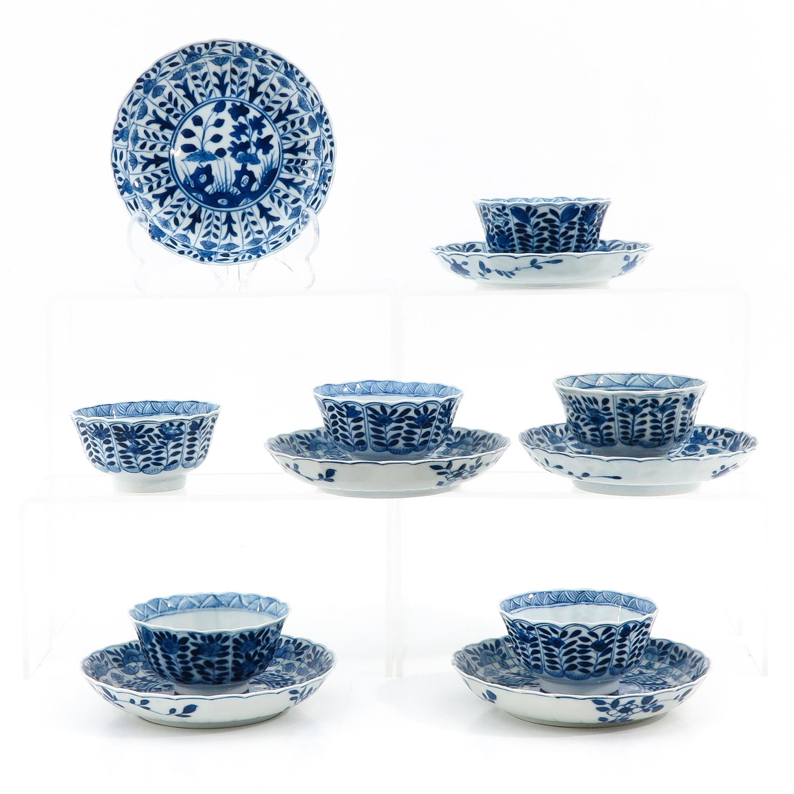 A Collection of 6 Cups and Saucers: Decorated with flowers in garden, Kangxi mark, saucers are 13 cm. in diameter, chip and hairline.