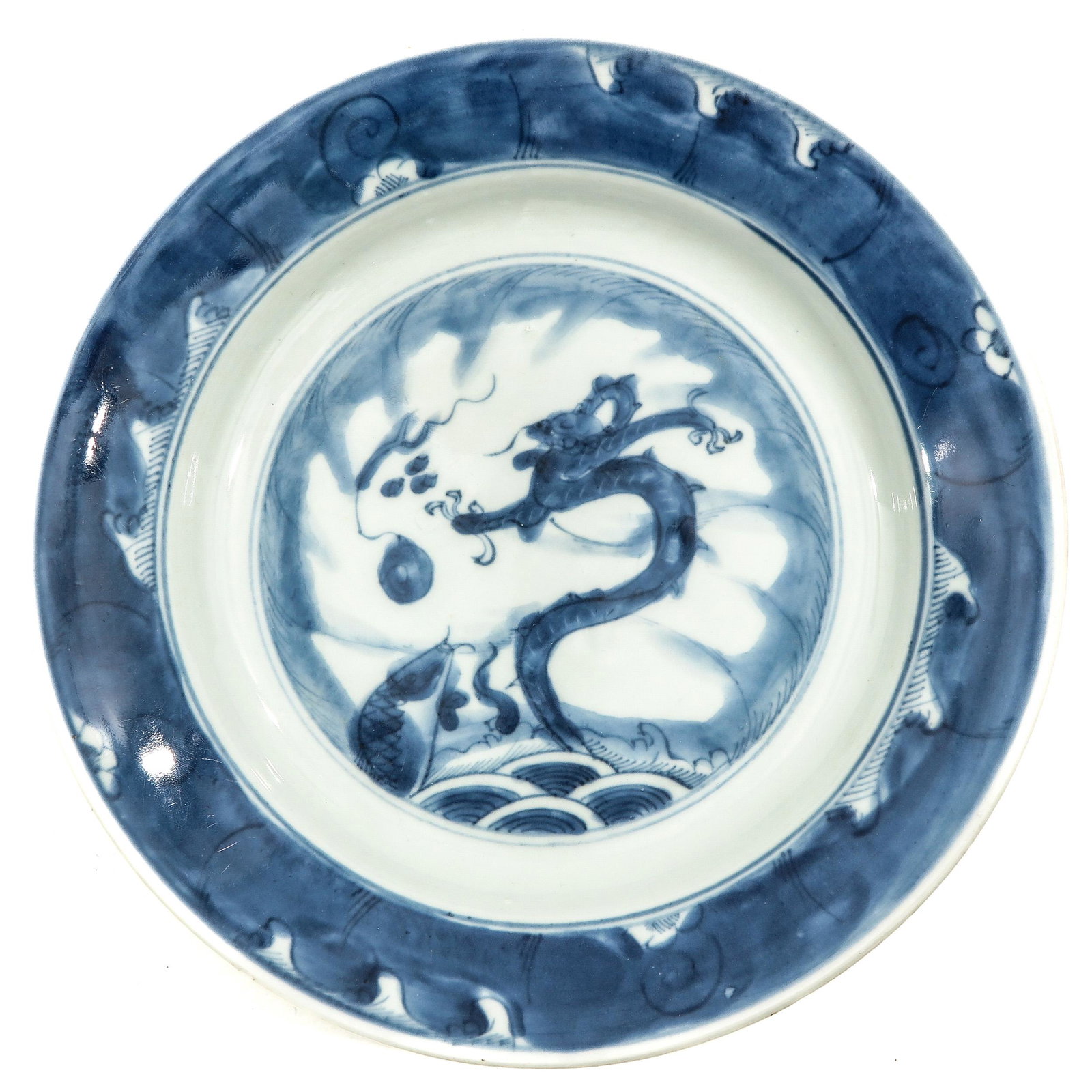 A Blue and White Plate: Depicting dragon with flaming pearl leaping out of water, 21 cm. in diameter, chip.