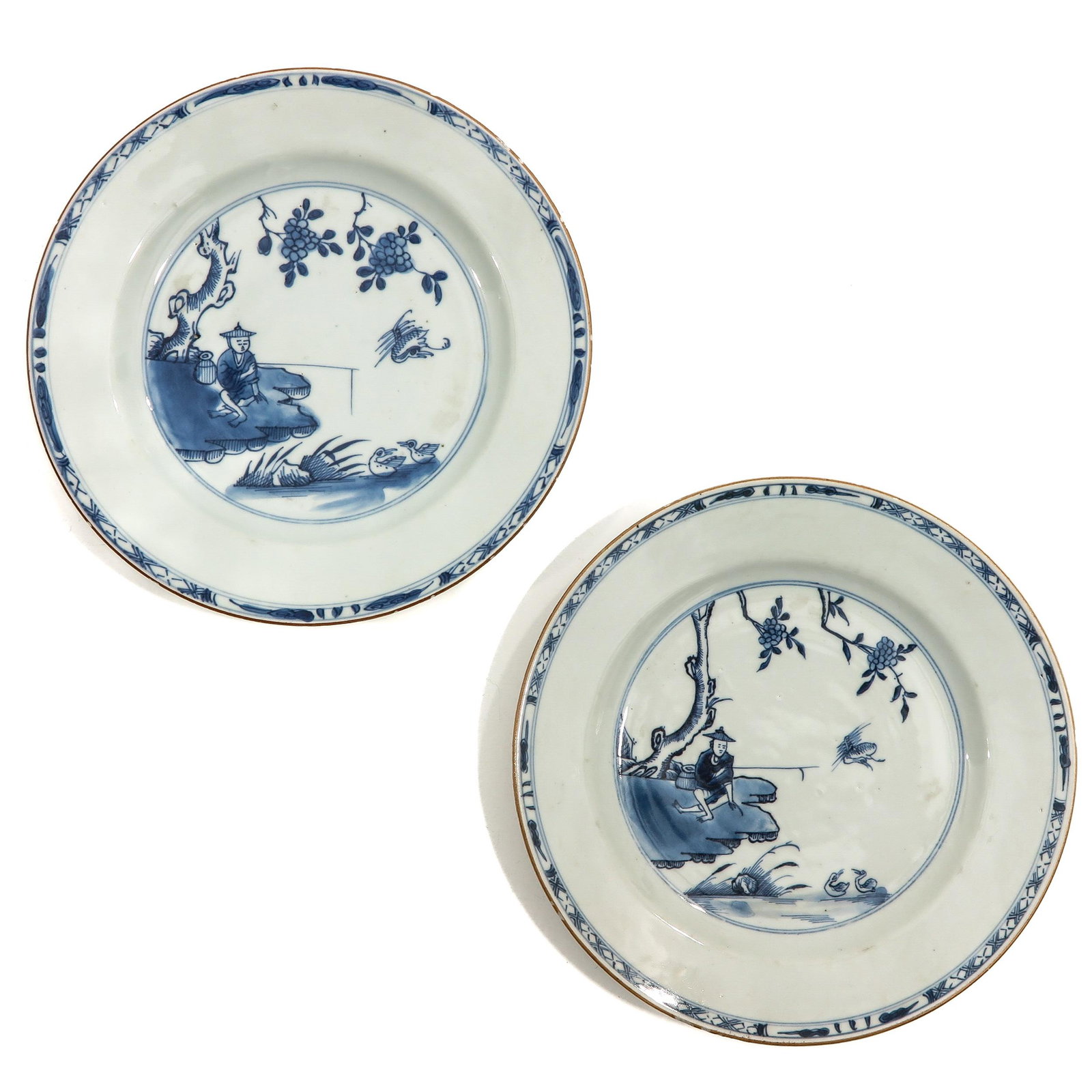A Pair of Blue and White Plates: Depicting Chinese fisherman, 23 cm. in diameter, chip.