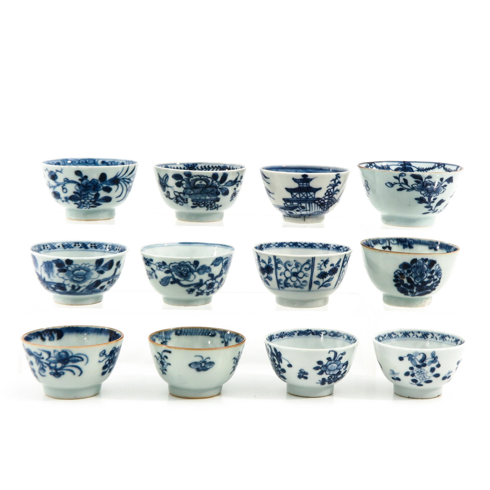 A Collection of 12 Blue and White Cups: Floral decor, largest cup is 9 cm. in diameter.