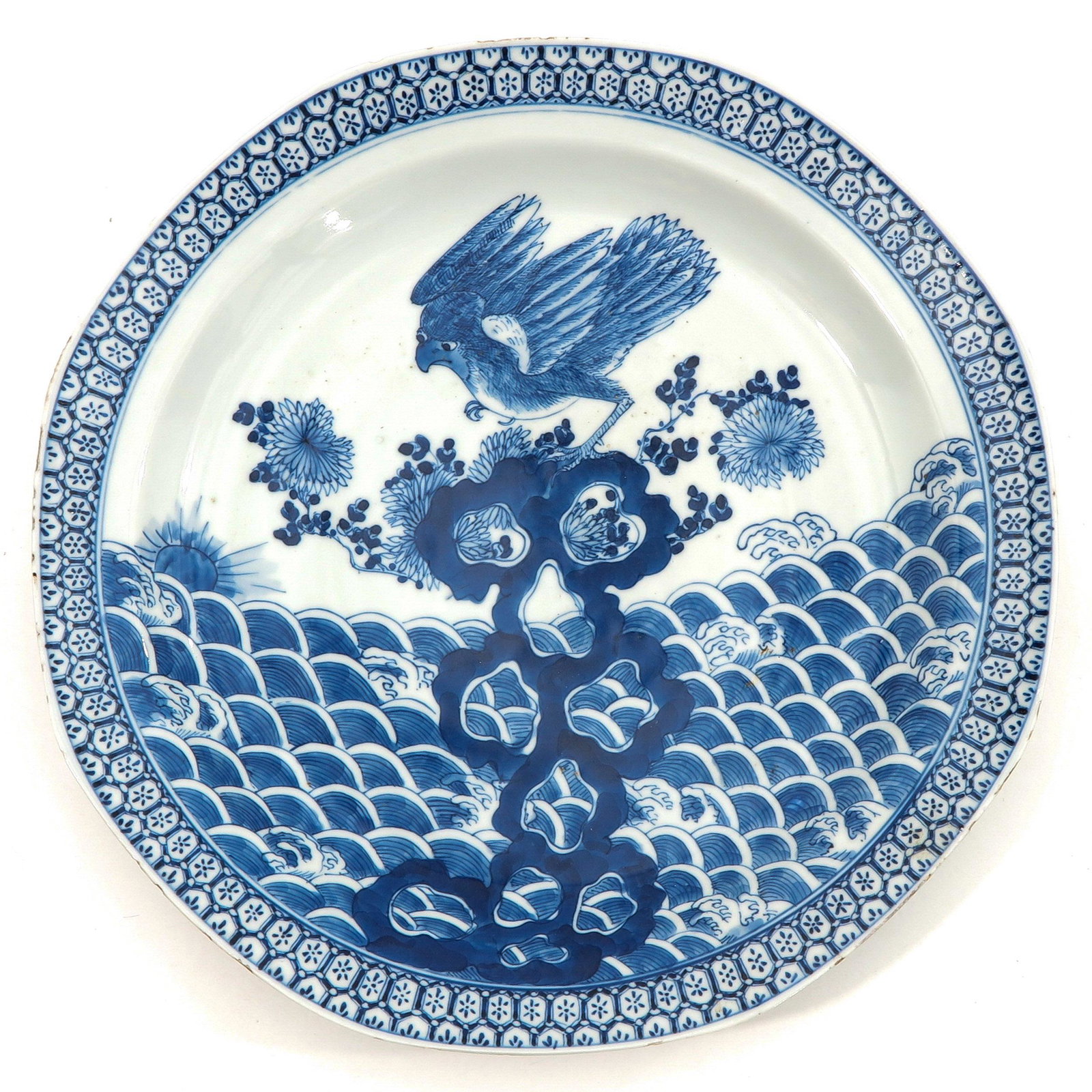 A Blue and White Charger: Depicting bird perched on rock over water, Kangxi mark, 32 cm. in diameter, chip.