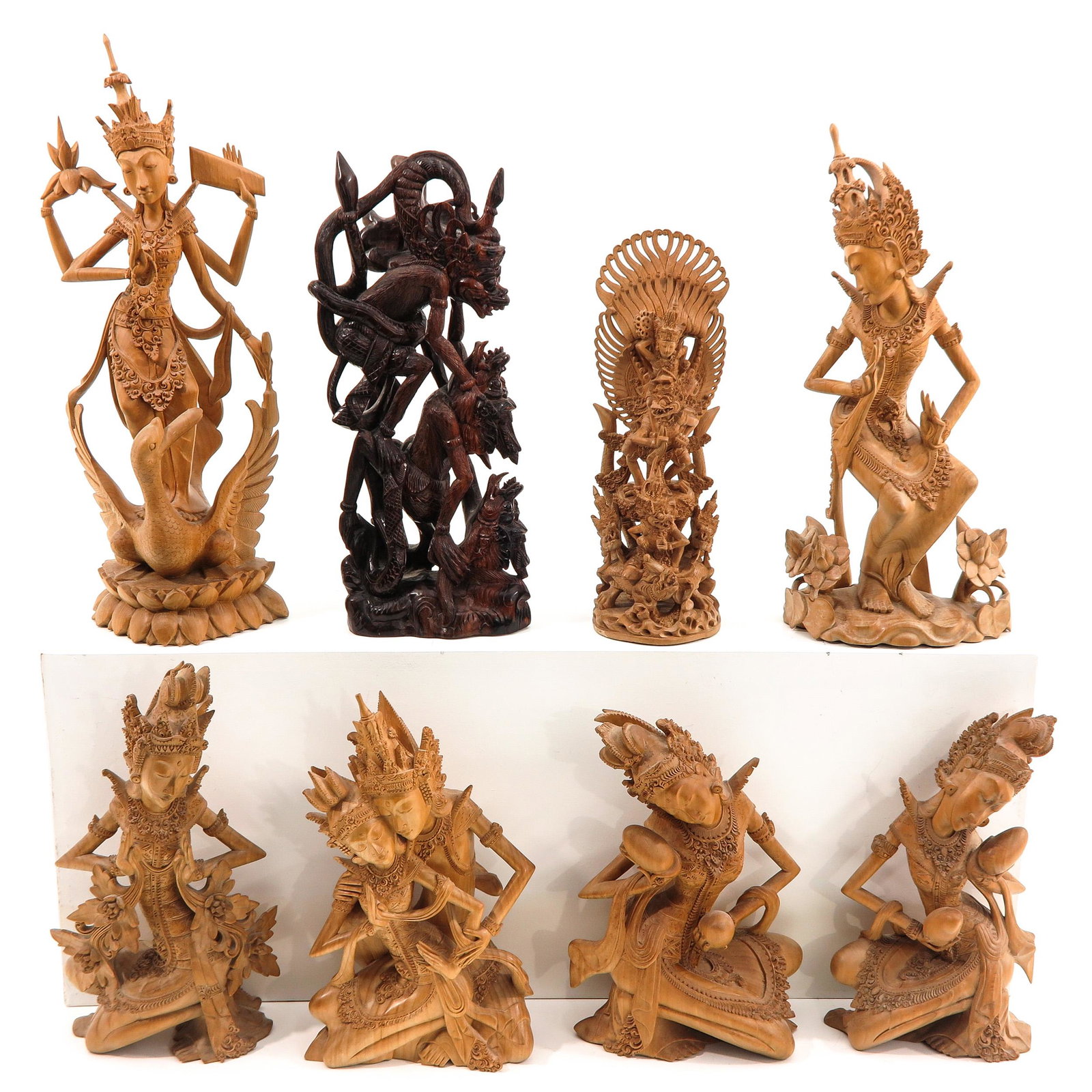 A Collection of 8 Carved Sculptures: Depicting Balinese dancers, tallest sculpture is 54 cm.