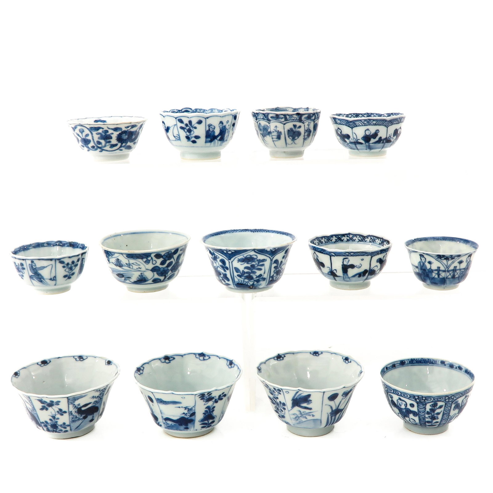 A Collection of 13 Cups: In a variety of blue and white decors, largest cup is 8 cm. in diameter, chip and hairline.