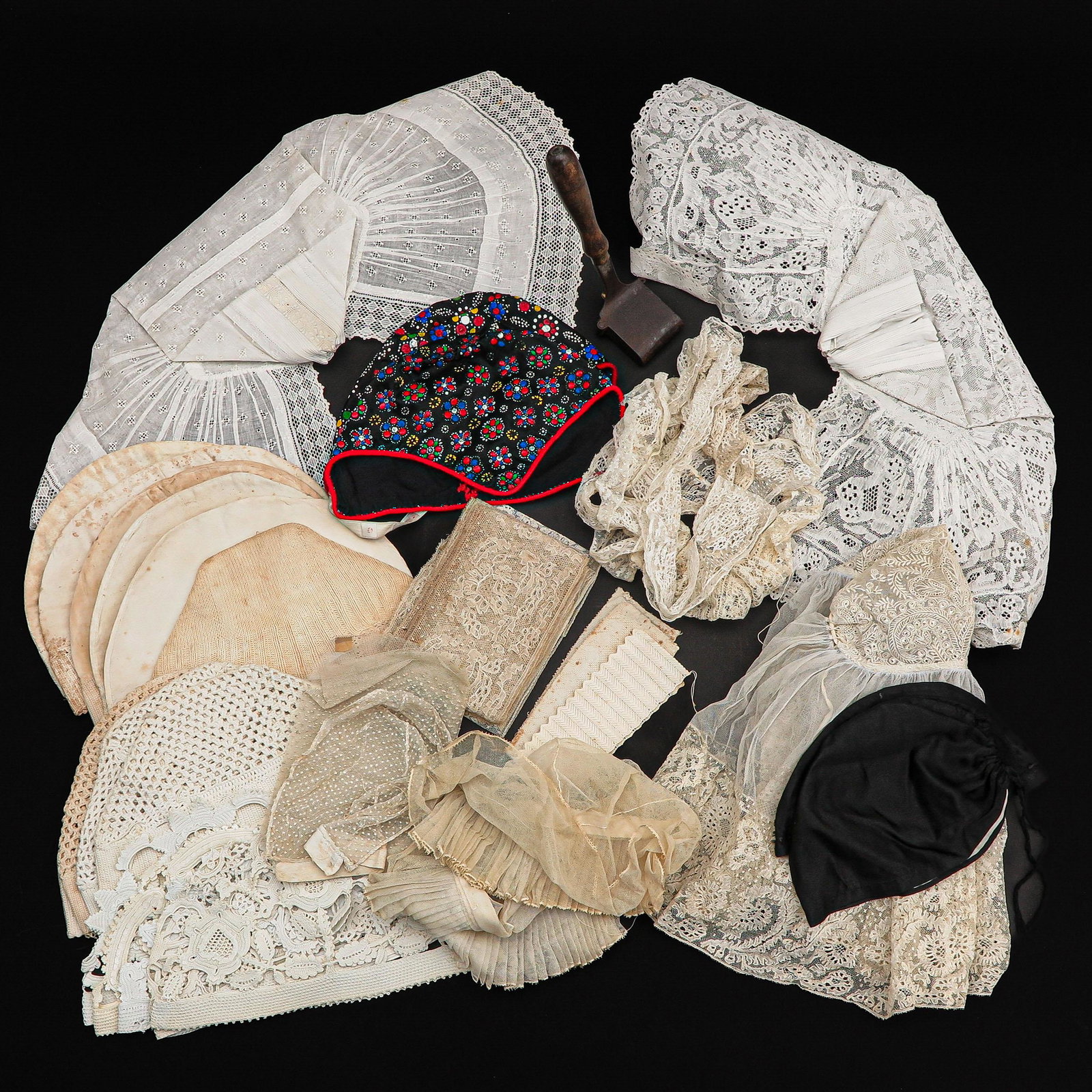 A Collection of Traditional Dutch Dress Items: Consisting of, among other things, a hat from Rozenburg made of Brussels lace, 2 hats from Zuid-Beveland, Staphorster children's hat, hats from Spakenburg and an iron.
