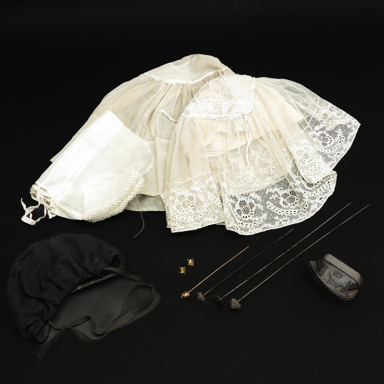 A Collection of Items Concerning Traditional Dutch Dress: Among other things, lace hats from various costumes, hat iron, pins and closure.