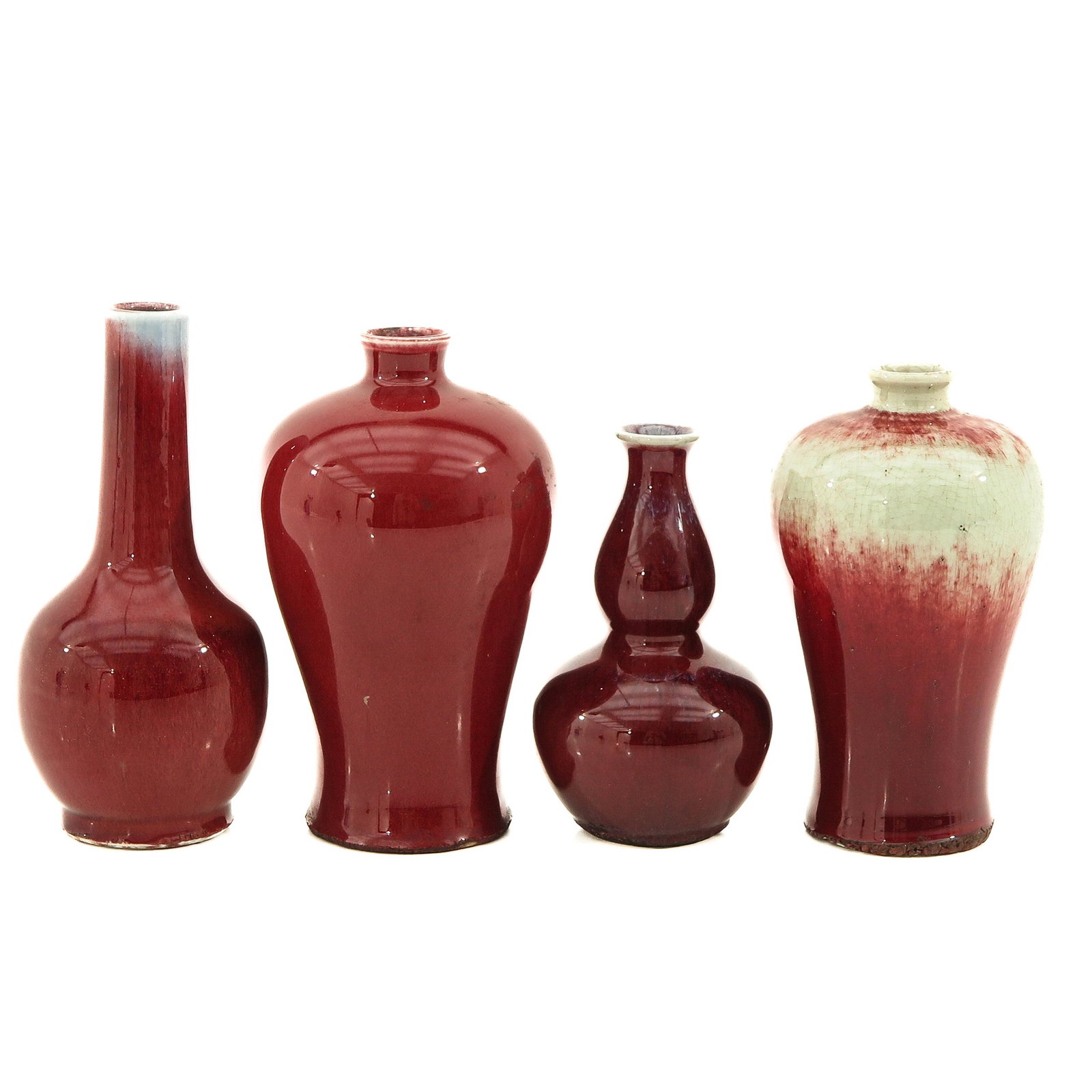 A Collection of 4 Sang de Boeuf Vases: In a variety of sizes, tallest vase is 20 cm., chip.