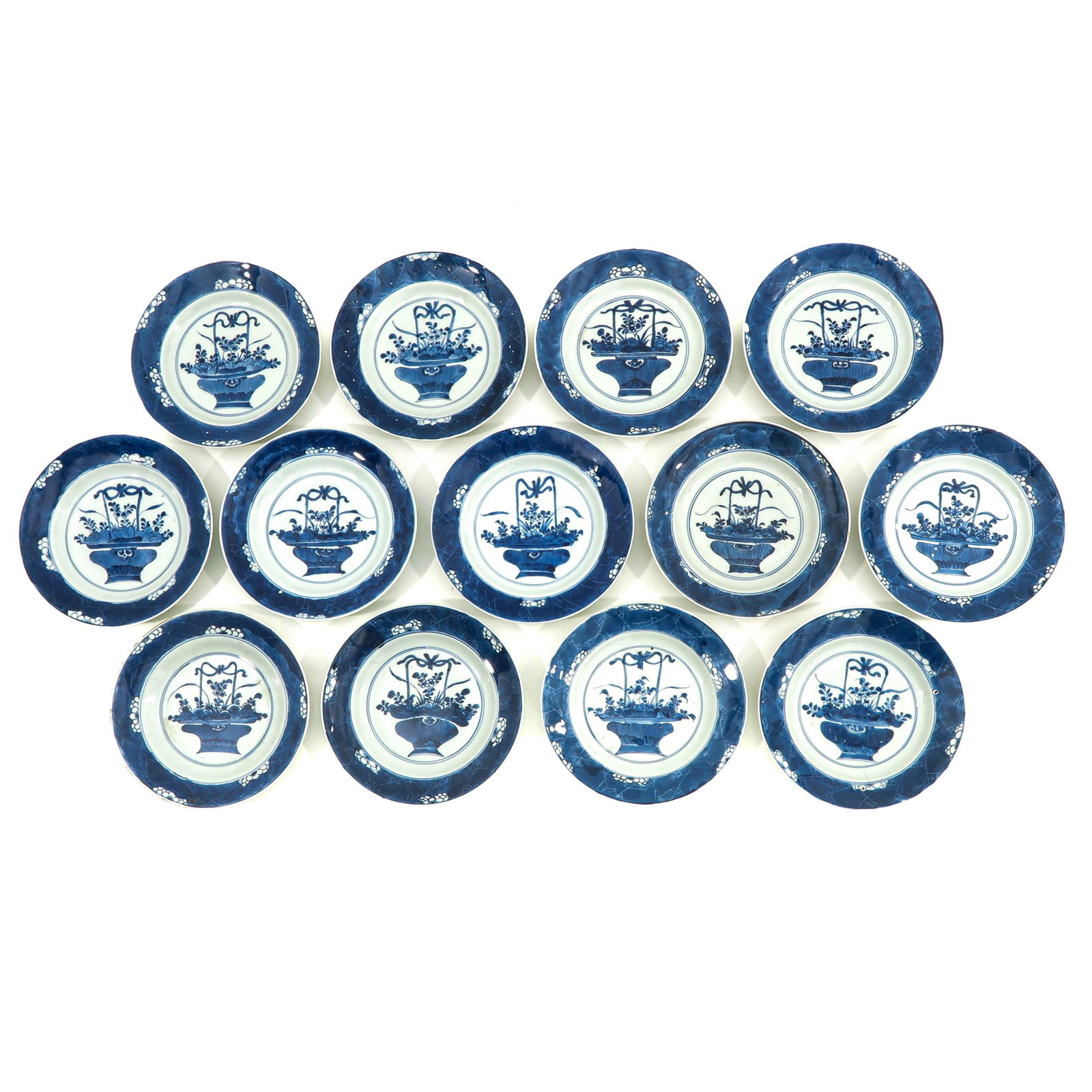 A Series of 13 Blue and White Plates: Depicting flowers in basket, marked with double ring and Lozenge, 22 cm. in diameter, in diverse conditions.