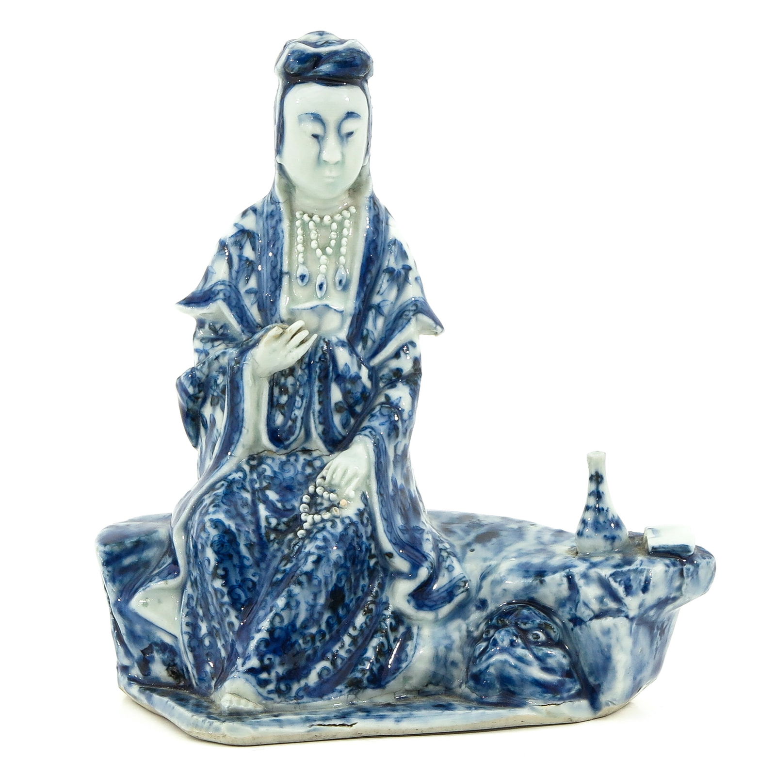 A Blue and White Chinese Quanyin Sculpture: Depicting lady sitting on bench, 16 cm. tall, one finger missing.