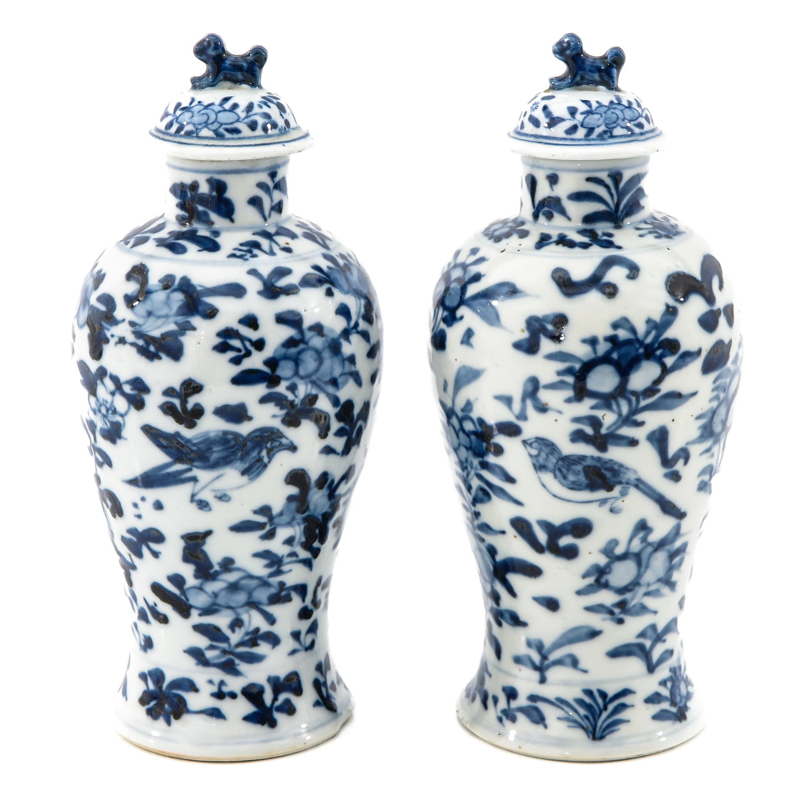 A Pair of Blue and White Garniture Vases: Decorated with flowers and birds, 21 cm. tall.