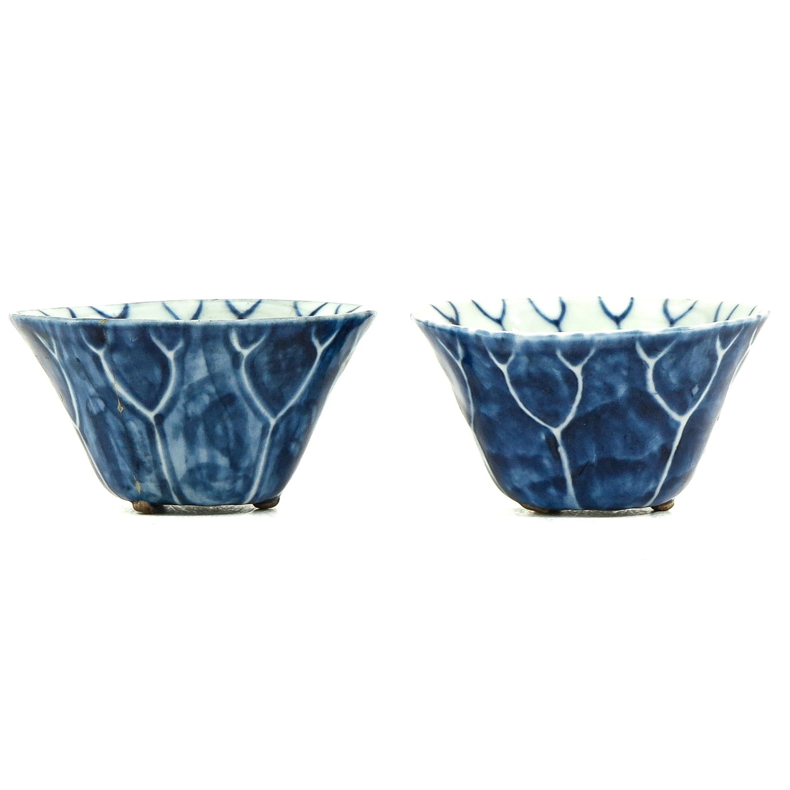 A Pair of Blue and White Cups: In the form of a lotus, 8 cm. long x 4 cm. tall, one is restored.