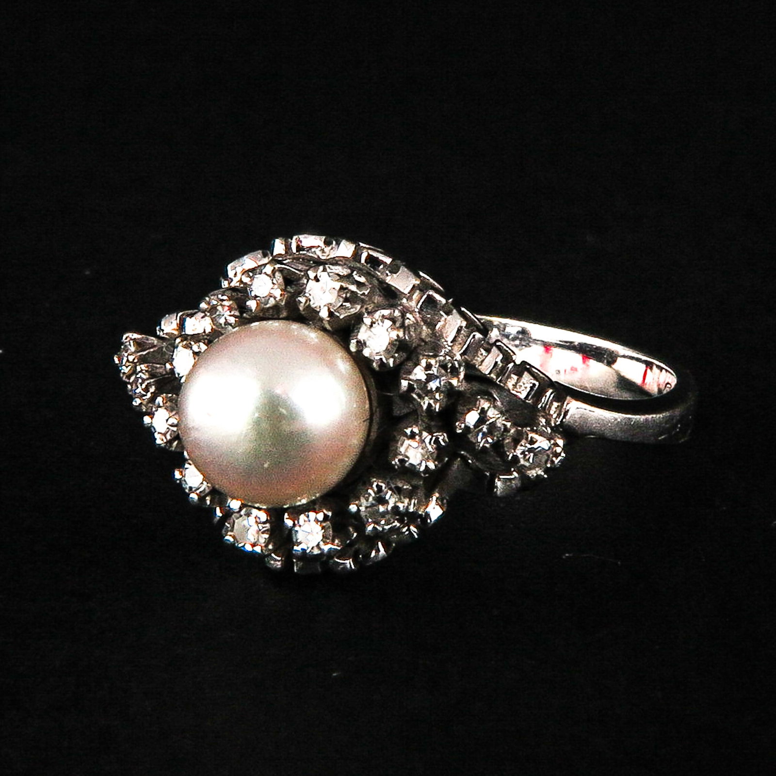 An 18k Gold Ladies Diamond Ring: Set with 16 brilliant cut diamonds and 1 pearl, ring size 17