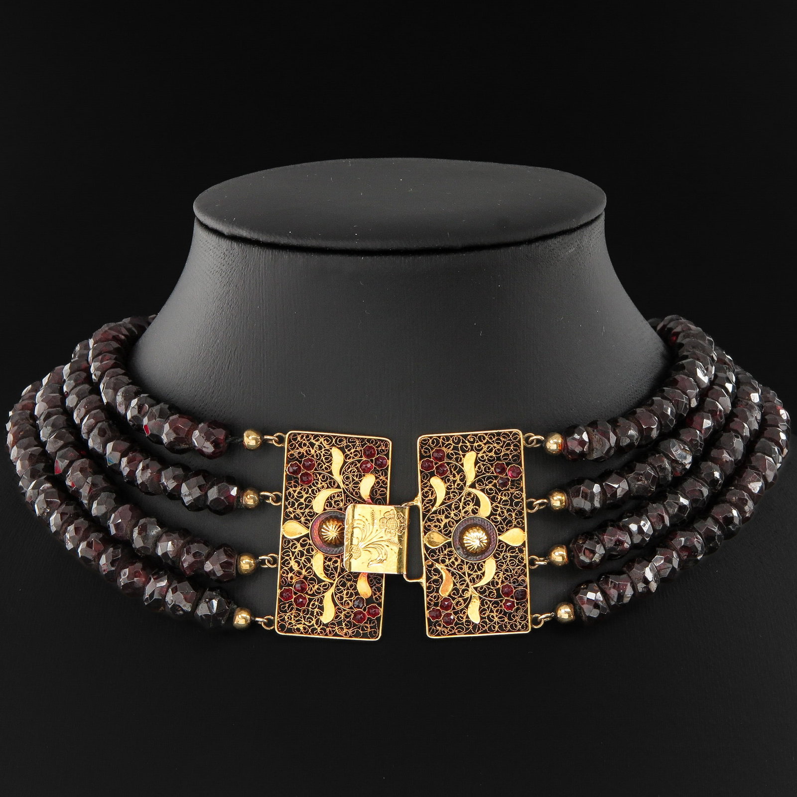 A Garnet Necklace: 4 rows of garnets on gold clasp