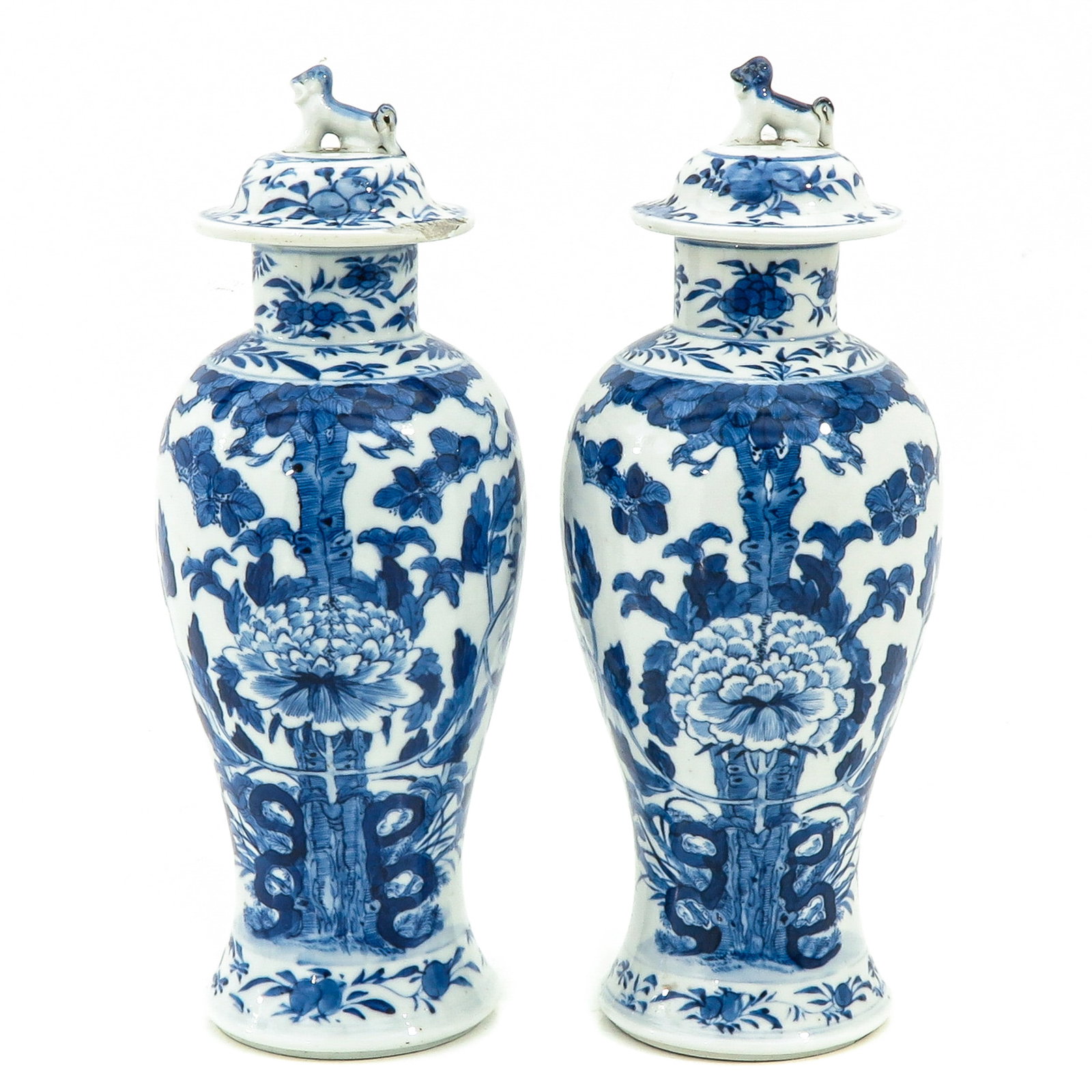 A Pair of Blue and White Vases with Covers: Floral decor, Kangxi mark, 28 cm. tall, chip.