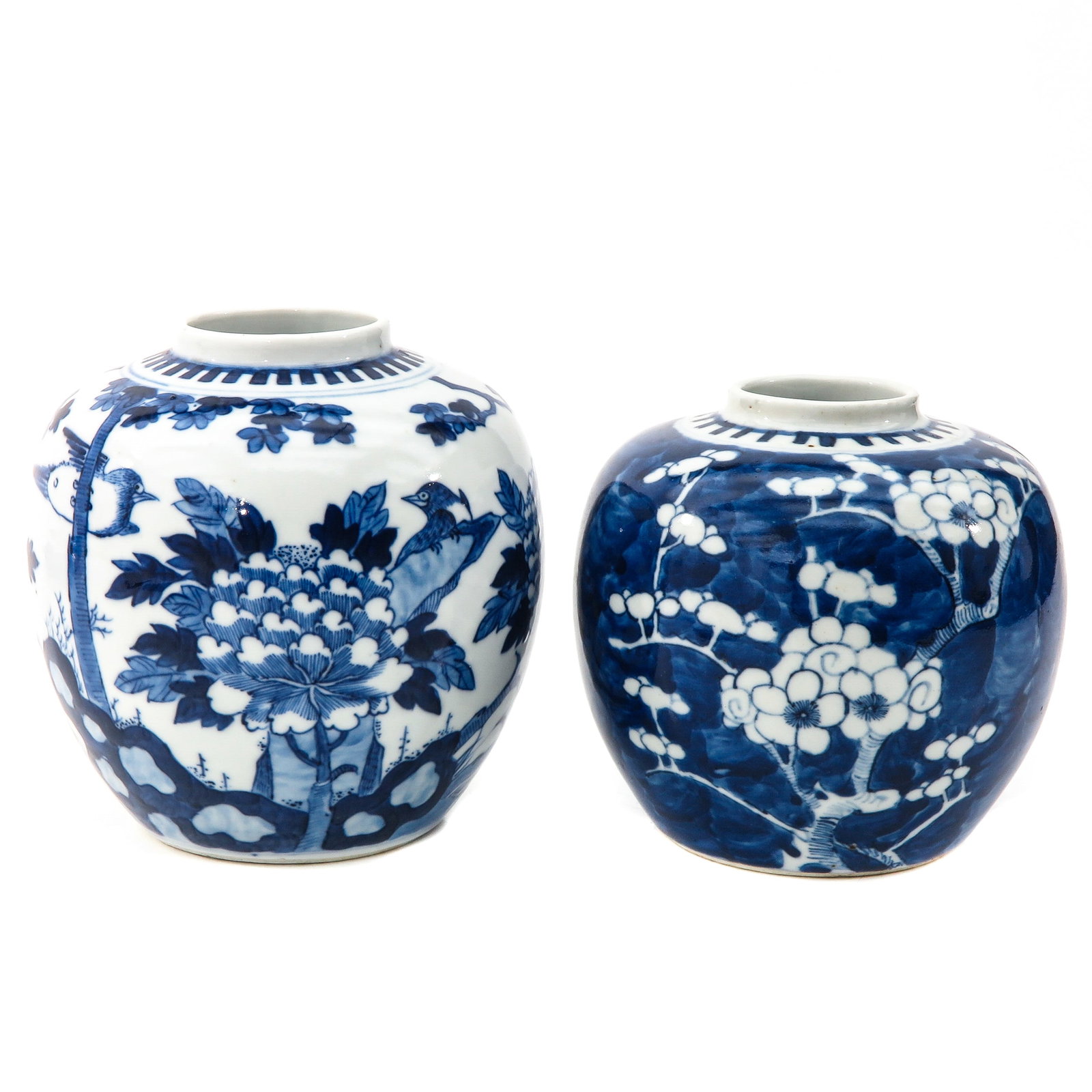 A Lot of 2 Blue and White Ginger Jars: Including decor with birds and flowers with Kangxi mark 15 cm. tall and blue ground with white flower blossoms 13 cm. tall.