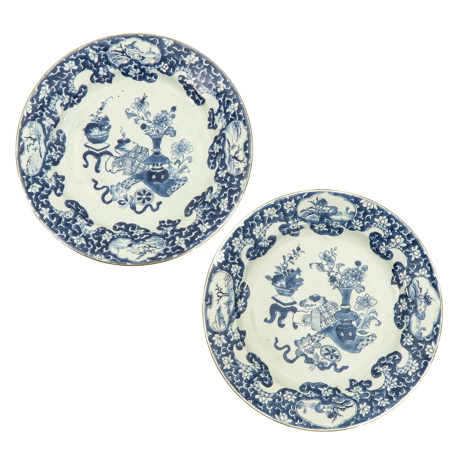 A Pair of Blue and White Antiquities Plates: Center of plates decorated with Chinese antiquities surrounded by landscape border, 18th Century, 28 cm. in diameter.