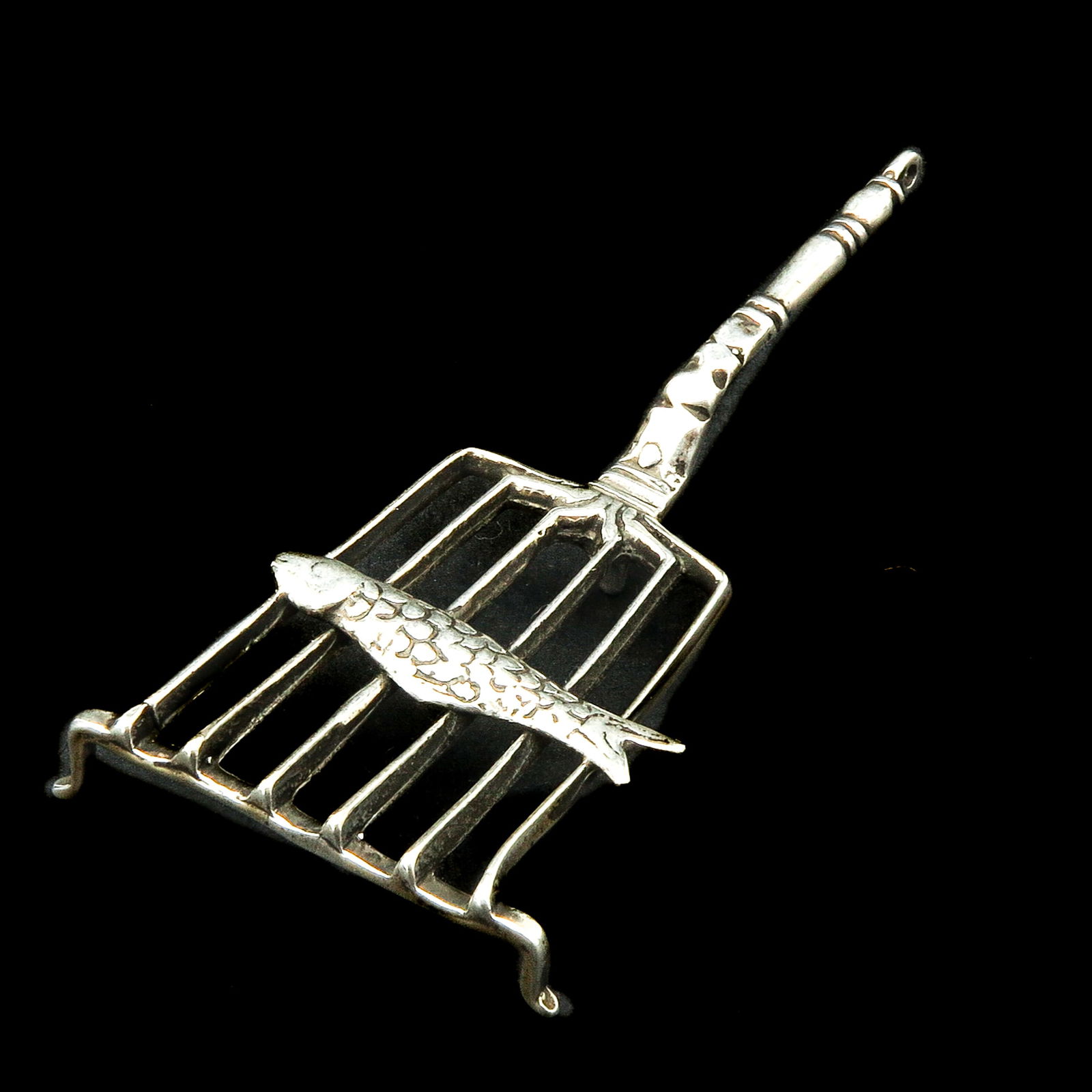 A Miniature Silver Trivet: trivet with fish, Netherlands, 18th century, length 63 mm.