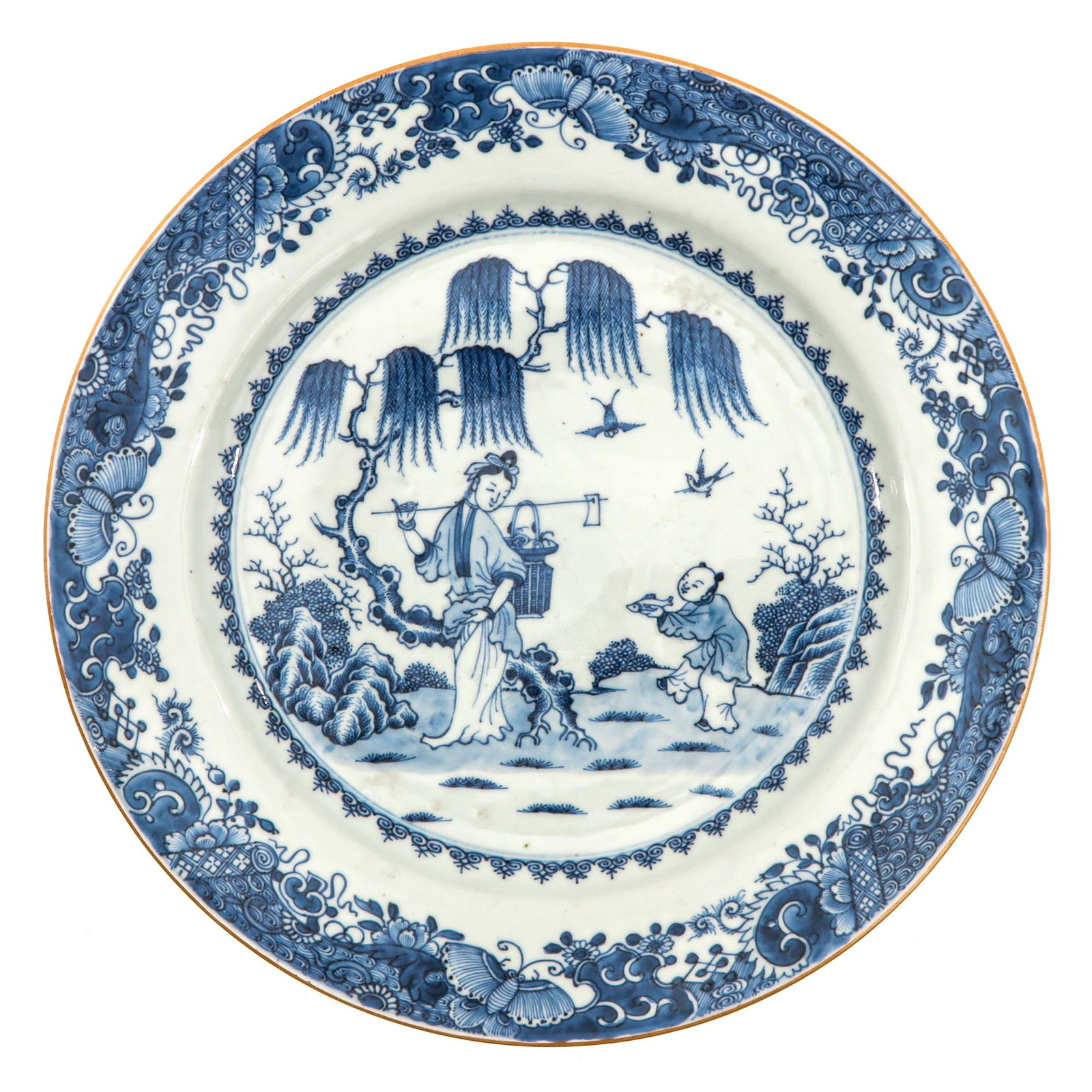 A Blue and White Charger: Depicting Chinese lady carrying a basket in garden with boy holding a fish, 18th Century, 31 cm. in diameter.